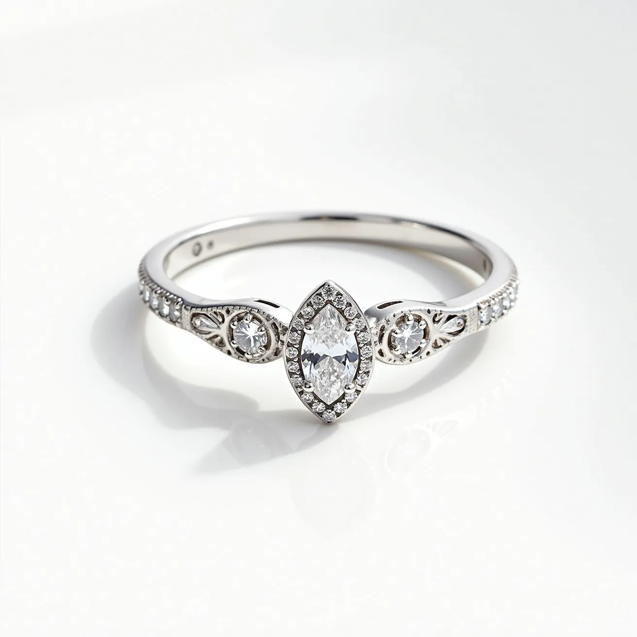 This moon ring features a polished metal band, likely made of white gold or platinum, which provides a sleek and elegant appearance. At the center, a marquise-cut diamond takes prominence, surrounded by a delicate halo of smaller round-cut diamonds that enhance its brilliance. Flanking the central stone are additional circular diamond accents, each set within intricate milgrain detailing that adds texture and vintage charm to the design. The side of the band is adorned with a series of smaller embedded round diamonds, contributing to the overall sparkle and refinement of the piece. The ring's elegant craftsmanship and detailed settings highlight its sophisticated style.