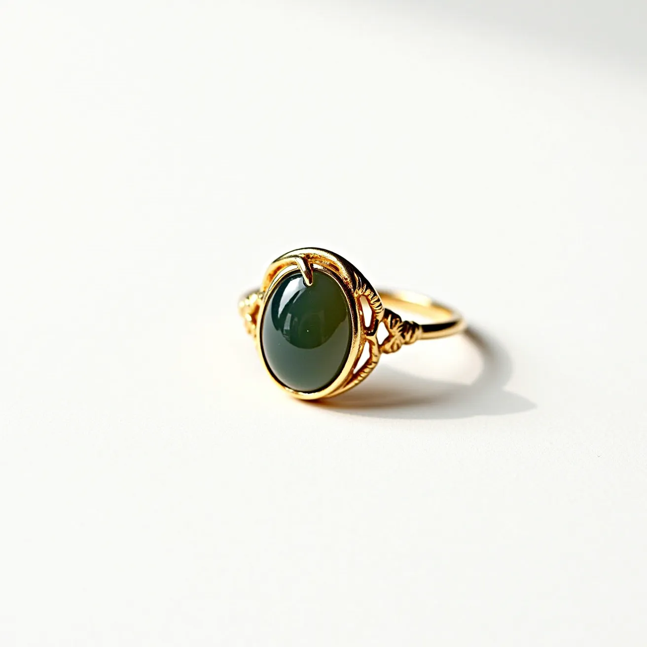 This moss agate ring features an oval-shaped moss agate stone set in a cabochon cut, highlighting its smooth, polished surface and rich, earthy tones. The stone is elegantly secured by a decorative bezel setting with intricately designed prongs, enhancing the natural beauty of the agate. The setting is crafted from a golden metal, adding a warm, luxurious contrast to the stone's natural patterns. Delicate floral motifs are incorporated into the band design, seamlessly integrating with the setting and lending an artistic elegance to the piece.