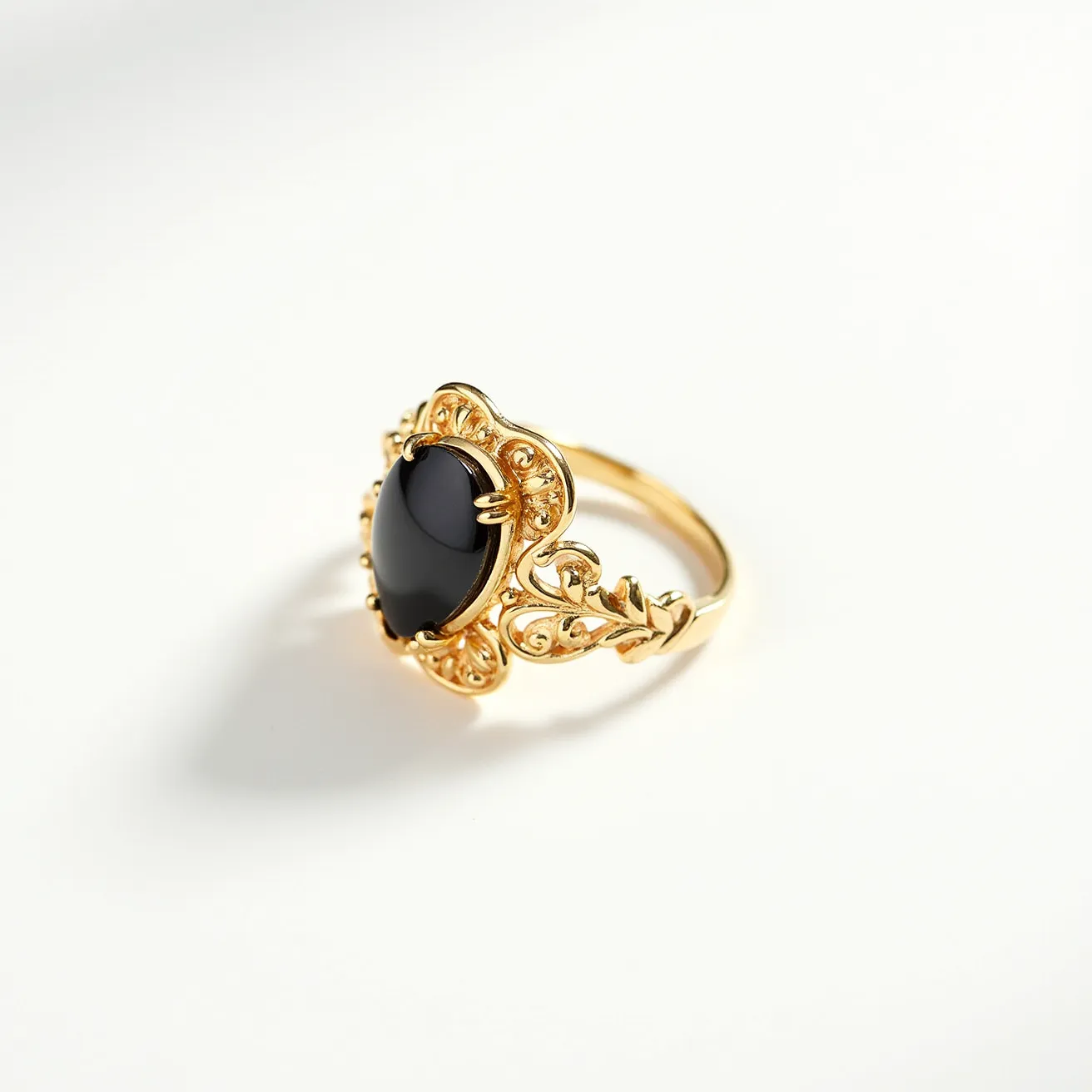 This moss agate ring features a striking dark gemstone set in a decorative gold band. The stone, which appears to be cut in an oval cabochon style, is securely held within an ornate gold setting that adds elegance to the ring's overall design. The band is crafted from gold, showcasing intricate detailing with scroll-like patterns that enhance its visual appeal. The ring boasts a classic prong setting that firmly holds the gemstone in place, ensuring both security and style.