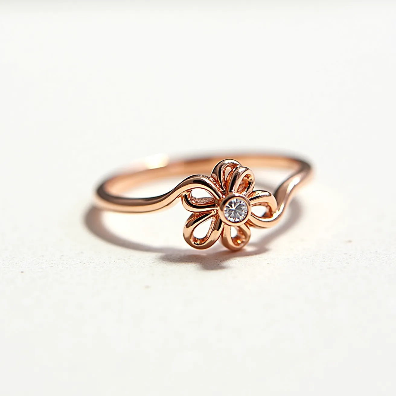 This mothers ring features a delicate flower design crafted from a warm-toned metal, likely rose gold, which gives it an elegant and timeless appeal. At the center of the flower is a small, round white gemstone, possibly a diamond or cubic zirconia, set in a bezel setting that adds to its subtle sparkle. The band itself is slender and gracefully curves around the finger, enhancing the overall feminine aesthetic of the piece. The attention to detail in the floral design makes this ring a meaningful and beautiful accessory.