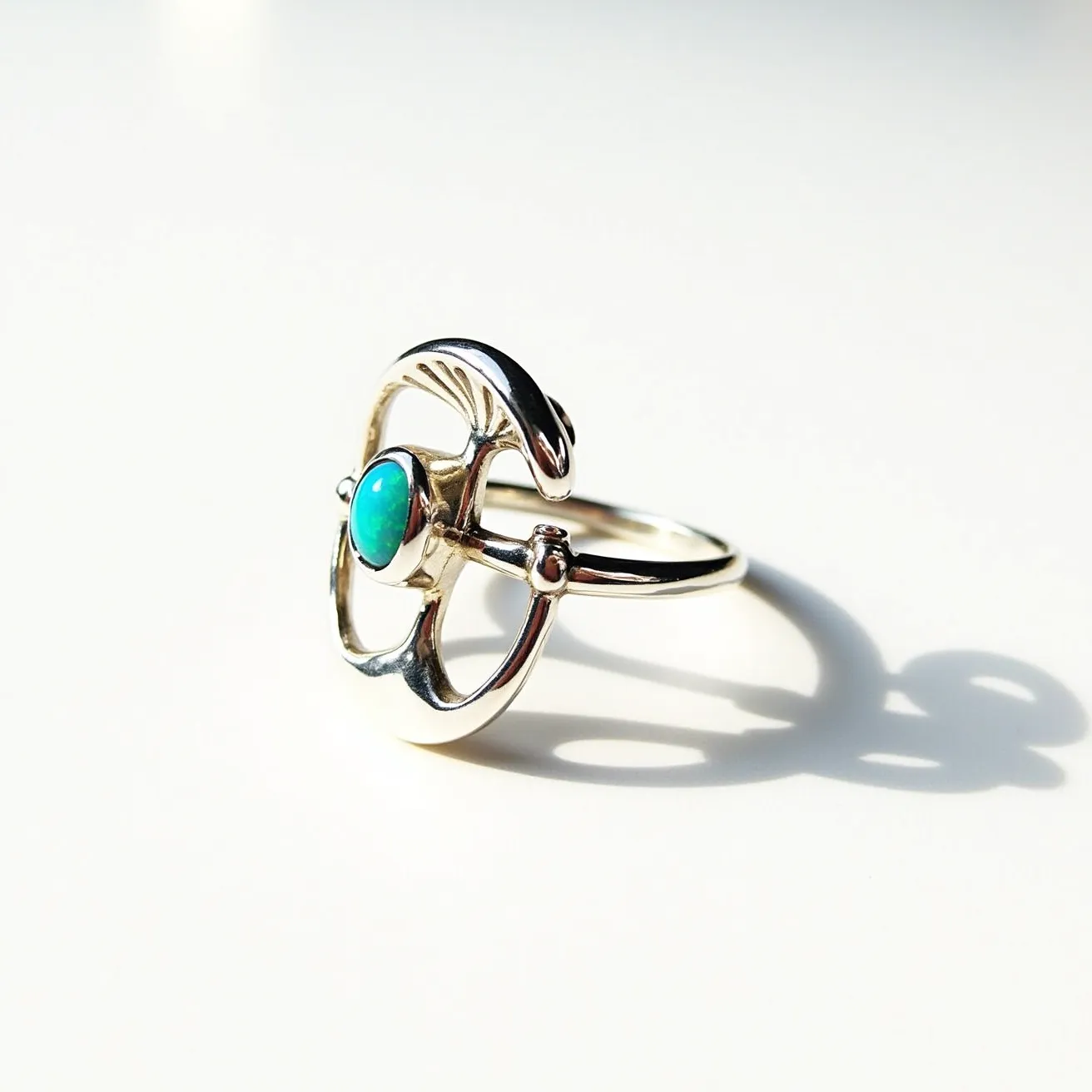 This mushroom ring features a unique design crafted from a metallic material, likely silver, which forms the band and mushroom motif. At the center, a polished turquoise gemstone is set prominently, its oval shape accentuated by a bezel setting that holds it securely. The design showcases intricate detailing that resembles a mushroom, adding an element of whimsy to the piece. The band is slender, complementing the central decorative element and creating an elegant look. The ring does not have any visible clasps or attachments, designed to be worn traditionally on the finger.