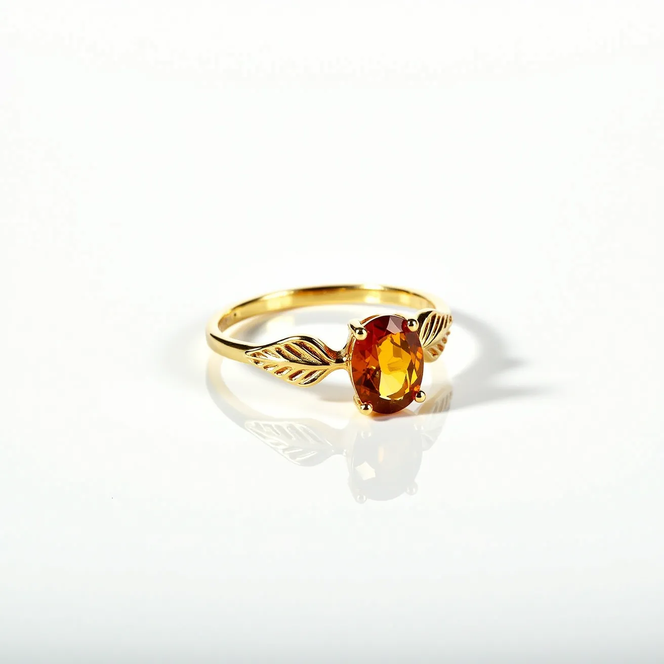 This November birthstone ring features a warm, amber-colored citrine gemstone that is oval cut, enhancing its natural brilliance and clarity. The citrine is elegantly set in a four-prong setting, securely holding the stone in place. The band of the ring is crafted from gold, complementing the rich tones of the gemstone. On either side of the citrine, there are intricate leaf-shaped accents, adding a touch of nature-inspired elegance to the design. The ring's overall composition is both sophisticated and timeless.