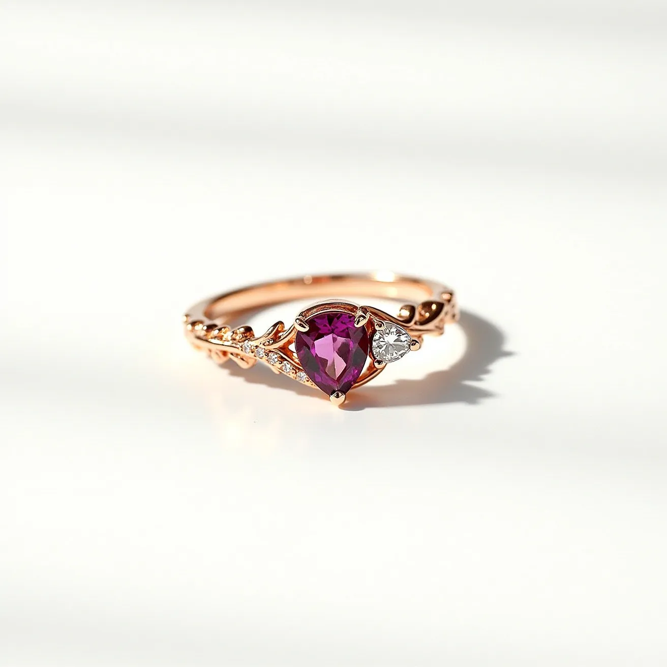 This October birthstone ring features a stunning pear-cut pink tourmaline as its centerpiece, set in an elegant rose gold band. The tourmaline is complemented by smaller, round-cut clear stones, possibly diamonds or cubic zirconia, set intricately along the band in a delicate leaf motif. The band itself is crafted with intricate detailing, enhancing the overall elegance and sophistication of the piece. The ring design emphasizes a harmonious blend of vibrant color and sparkling accents, making it both a stylish and meaningful accessory.