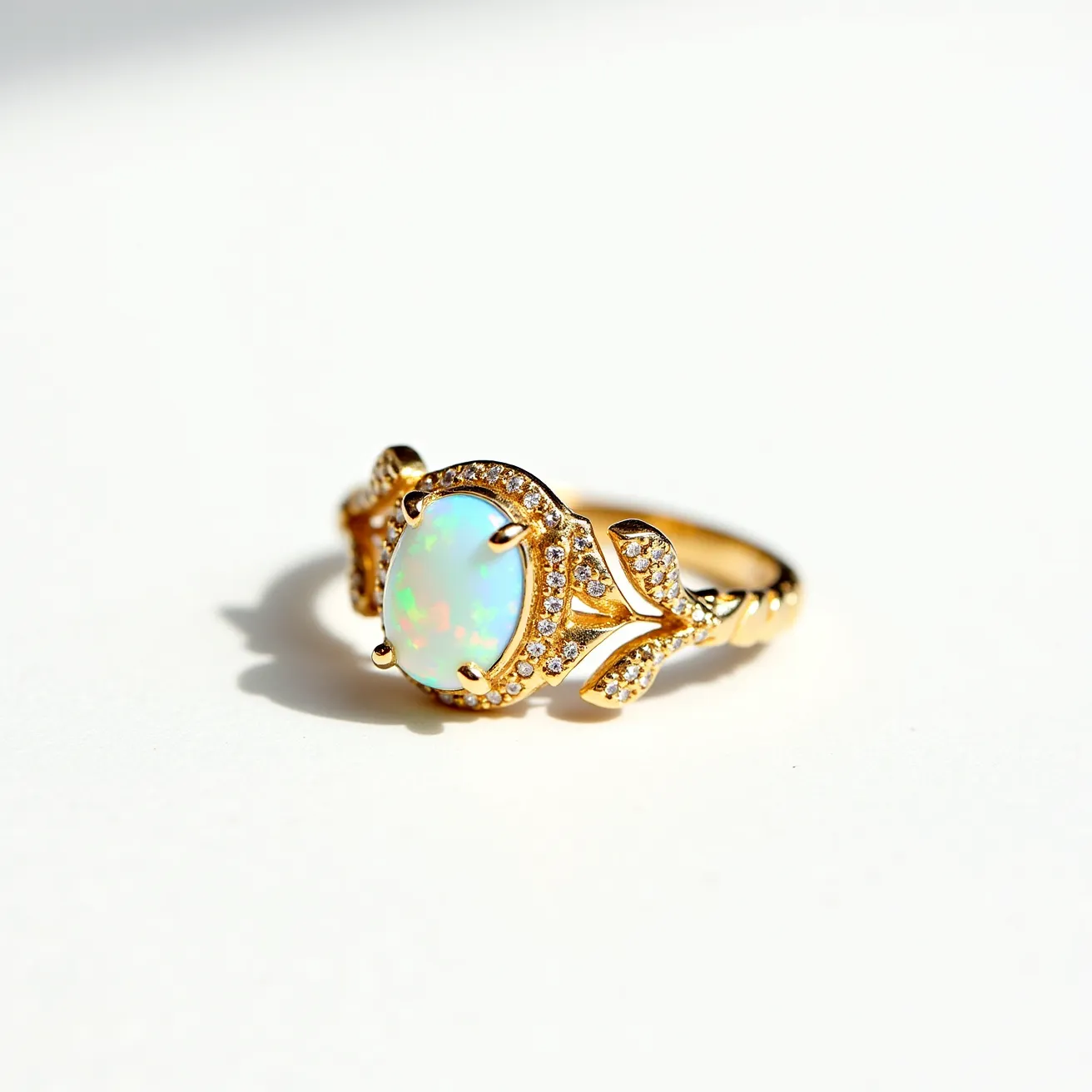 This opal ring features a striking oval-shaped opal set centrally in a claw setting, framed with a halo of small, round brilliant-cut diamonds. The opal displays a captivating play of colors, adding a unique vibrancy to the piece. The band is crafted from gold and adorned with additional small diamonds in a floral-inspired design, enhancing the ring's elegance and complementing the central opal. The intricate detailing and combination of materials create a harmonious and luxurious appearance.