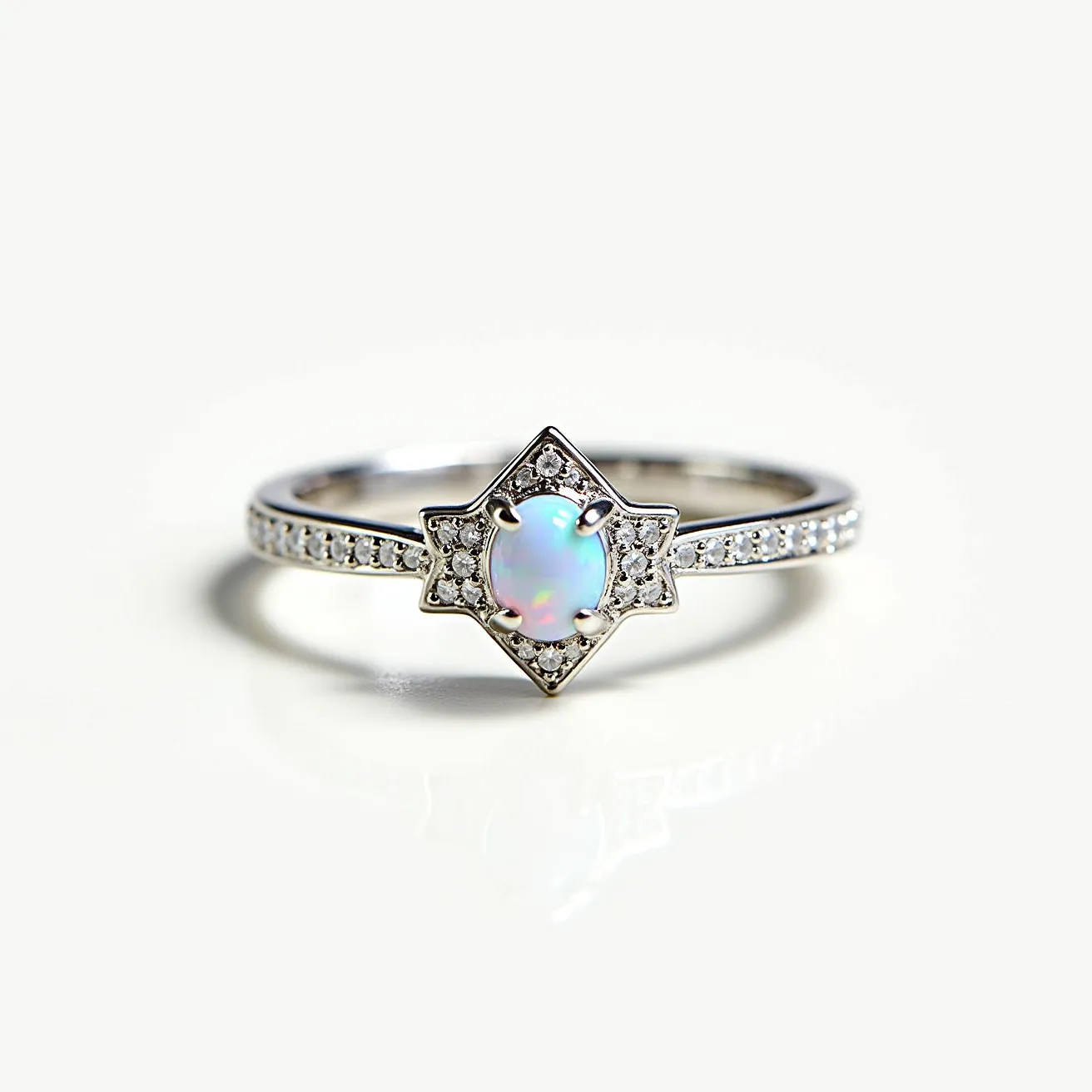 This opal ring features a central oval opal stone that exhibits a beautiful play of color, set in a prong setting. The opal is surrounded by a star-shaped halo of small round-cut diamonds, which are also encrusted along the band, enhancing the ring's overall sparkle. The band appears to be made of a shiny metal, likely white gold or platinum, adding to the ring's elegance and modern appeal. The design integrates both classical and modern elements, making it versatile for various occasions. The setting ensures that the opal is both secure and prominently displayed.