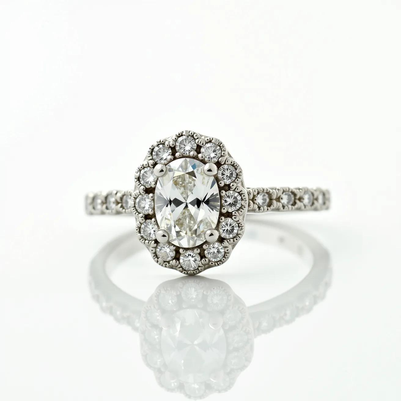 This oval diamond ring features a central oval-cut diamond encircled by a halo of smaller round diamonds, all set in a white metal band, likely platinum or white gold, enhancing its brilliance. The pavé setting extends onto the band, with additional small diamonds lining the shoulders, creating an elegant and cohesive design. The prong setting securely holds the central diamond, while the halo adds extra sparkle and visual interest. The overall craftsmanship showcases a refined aesthetic, making it a striking piece of jewelry.