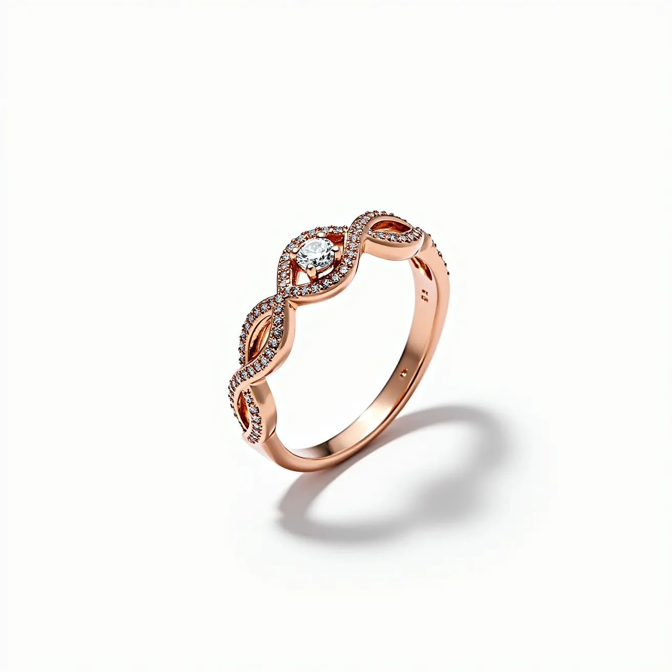 This pave ring features a graceful design crafted in rose gold, with a delicate swirling band embellished with numerous small, round-cut diamonds set closely together in a pave setting. At its center, the ring showcases a larger, round brilliant-cut diamond accentuated by a halo of additional diamonds, providing a striking focal point. The intricate metalwork and precise stone placement highlight the elegance and luxury of the piece, making it an exquisite example of fine jewelry craftsmanship.