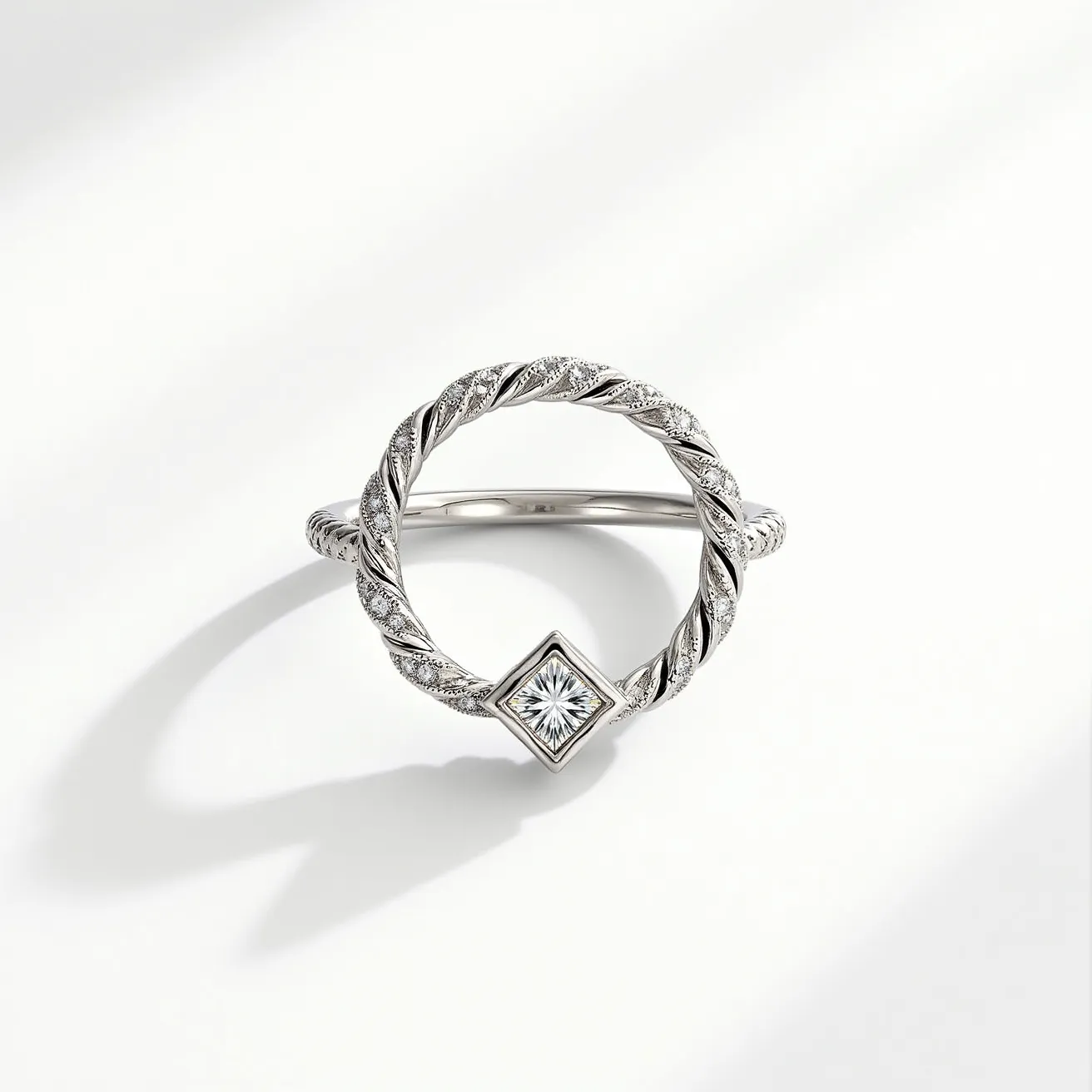 This pave ring features an elegantly twisted design crafted from a lustrous white metal, likely platinum or white gold. The ring's circular shape is enhanced with delicate pavé-set diamonds, which exude a subtle sparkle, accentuating the twisted pattern. At the center of the ring sits a prominently set diamond with a princess cut, embedded within a square bezel setting. This central stone is strategically placed to catch the light, creating a brilliant focal point. There are no additional clasps or attachments, allowing the ring’s design to stand out in its simplicity and timeless elegance.