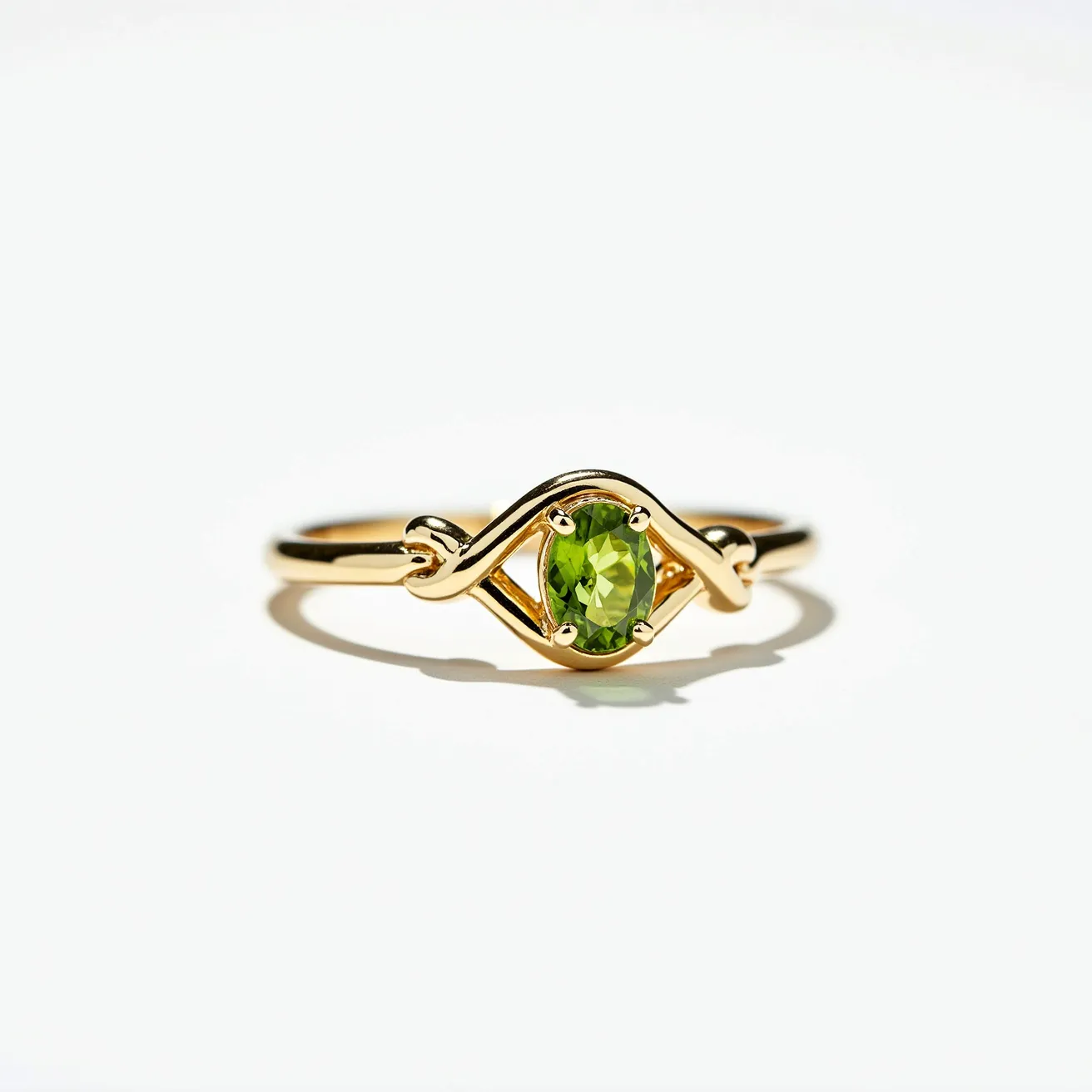 This peridot engagement ring features a vibrant, round-cut peridot gemstone set in a delicate prong setting. The band appears to be crafted from polished gold, forming an intricate infinity design that elegantly frames the stone. The overall design is simple yet sophisticated, highlighting the vivid green hue of the peridot. The prongs securely hold the gemstone in place, ensuring its central position on the ring.