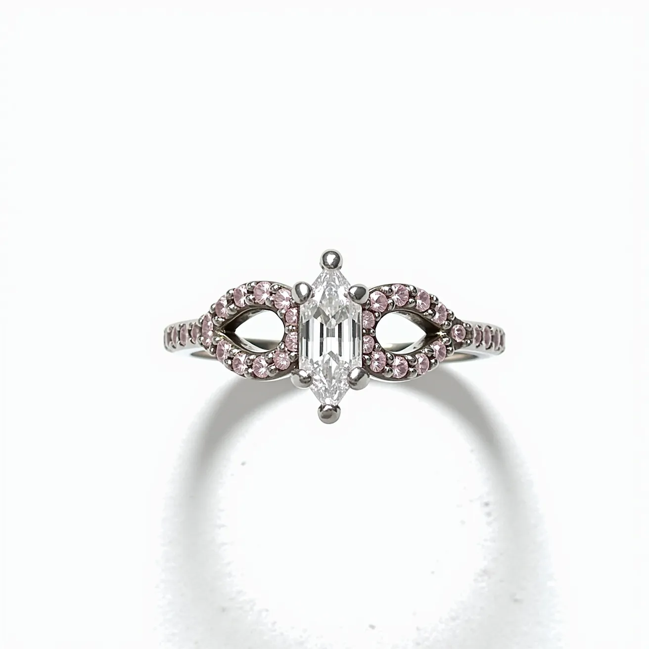 This pink diamond ring features a central marquise-cut diamond elegantly set in a four-prong setting, flanked by a band encrusted with small, round pink diamonds. The band is intricately designed with openwork patterns that add a delicate and sophisticated touch. The pink diamonds are likely set in a white gold or platinum band, enhancing their rosy hues and providing a sleek, polished finish. The ring showcases a harmonious blend of classic elegance and modern design elements, making it a striking piece that captures attention.