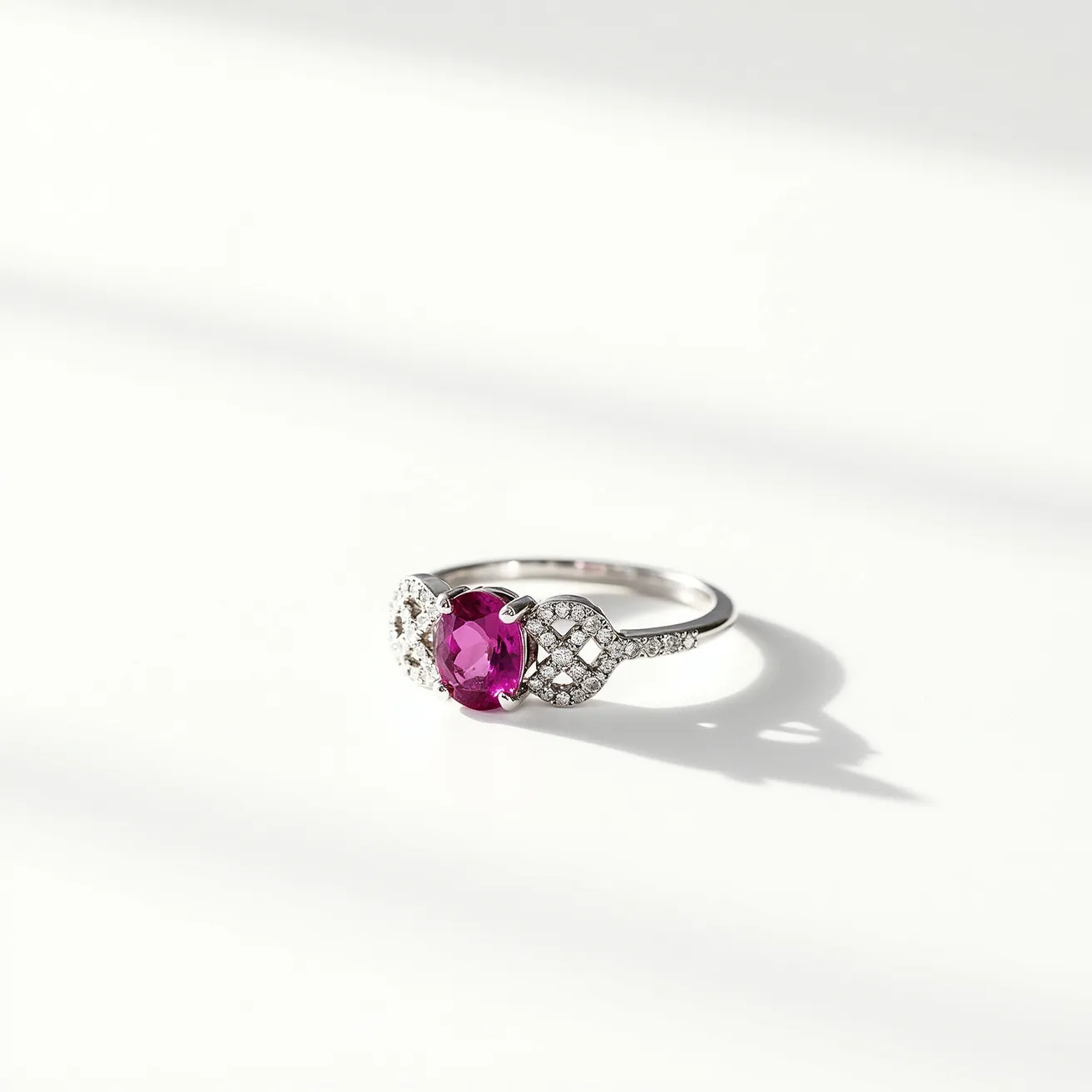 This pink diamond ring features a vibrant oval-cut pink gemstone as its centerpiece, delicately flanked by intricate settings of small round diamonds. The band itself is crafted from a lustrous white metal, likely platinum or white gold, which complements the sparkle of the gemstone and diamonds. The side stones are arranged in a pave setting that enhances the elegance of the central gem. The overall design combines classic and modern elements, offering a sophisticated aesthetic.