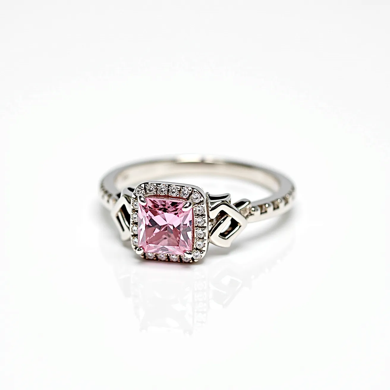 This pink diamond ring features a vibrant square-cut pink diamond at its center, surrounded by a halo of small, clear diamonds that enhance its brilliance. The band is crafted from a polished metal, likely white gold or platinum, contributing to the ring's elegance and durability. The setting includes intricate side designs that add a touch of sophistication and intricacy to the overall appearance. The ring is precisely designed to hold the central gem securely while providing a beautiful, eye-catching display.