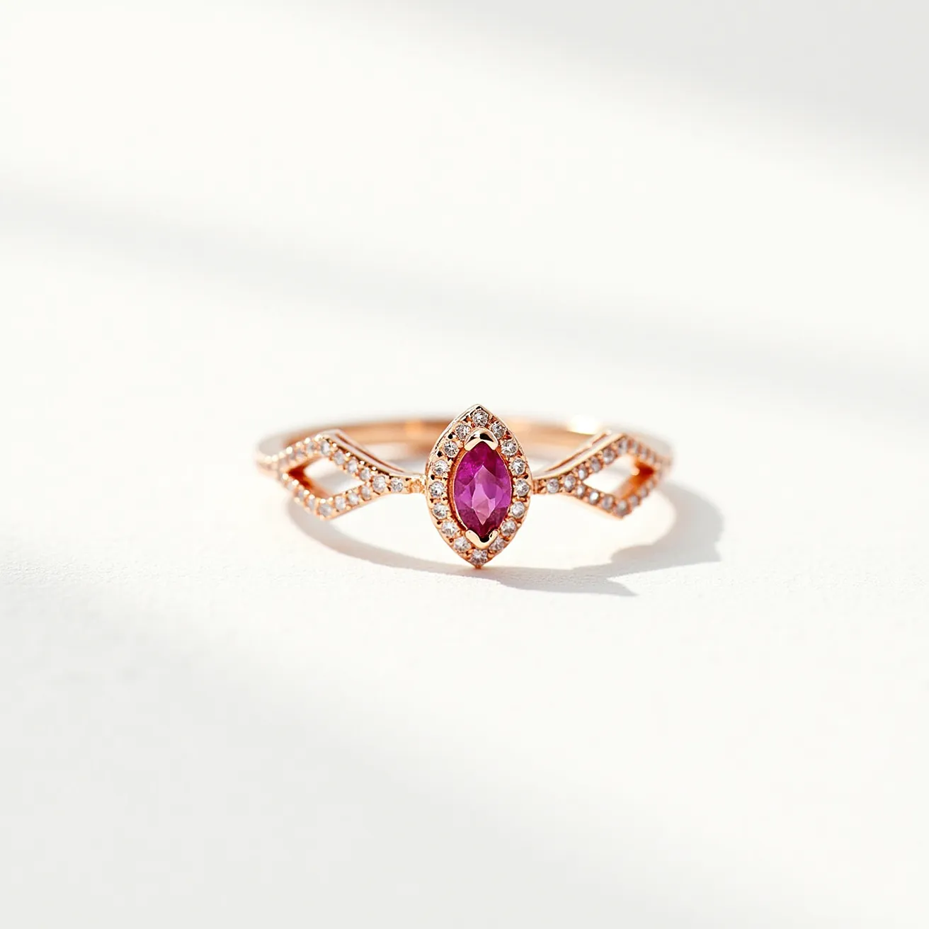 This pink sapphire ring showcases a marquise-cut pink sapphire as its centerpiece, encircled by a halo of small round white stones, likely diamonds, enhancing its brilliance. The band features an elegant, openwork design that is also adorned with small, similarly styled white stones, creating a cohesive and sparkling appearance. The ring is crafted from a metal with a rose gold hue, adding warmth and sophistication to the overall design. The setting employs a secure bezel or prong style, ensuring the pink sapphire is prominently displayed and securely fastened. The combination of the pink sapphire and the rose gold creates a harmonious and luxurious aesthetic.