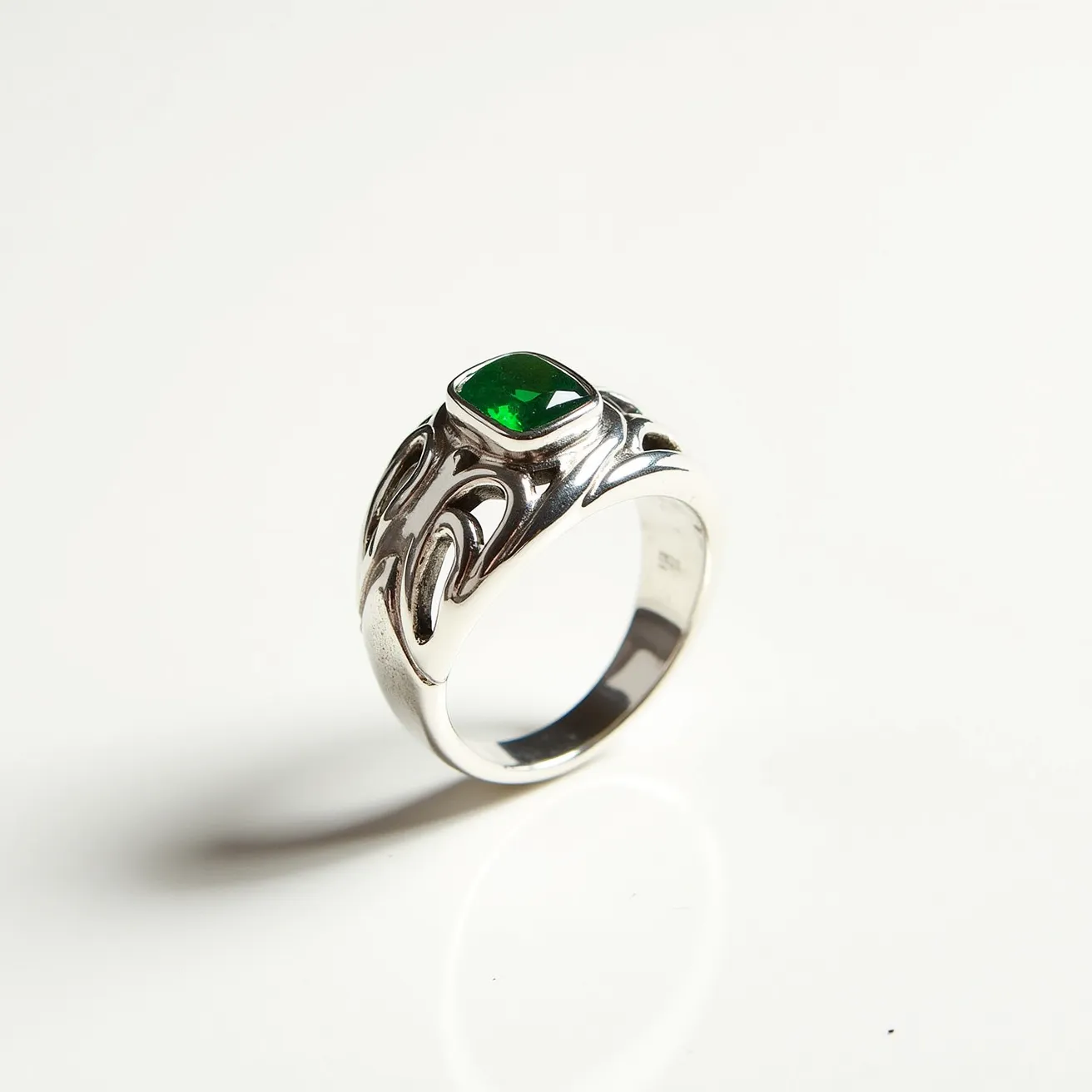 This prasiolite ring features a vibrant green stone, potentially prasiolite, prominently set in a bezel setting that ensures security and highlights the gem's beauty. The stone is skillfully cut into a rectangular shape with softened edges, enhancing its reflective qualities and depth. The band, likely made of either silver or white gold, complements the stone with its lustrous finish and intricate, artistic designs that add a touch of elegance and uniqueness to the piece. The ring's construction allows it to be worn smoothly, making it both a stylish and practical accessory.