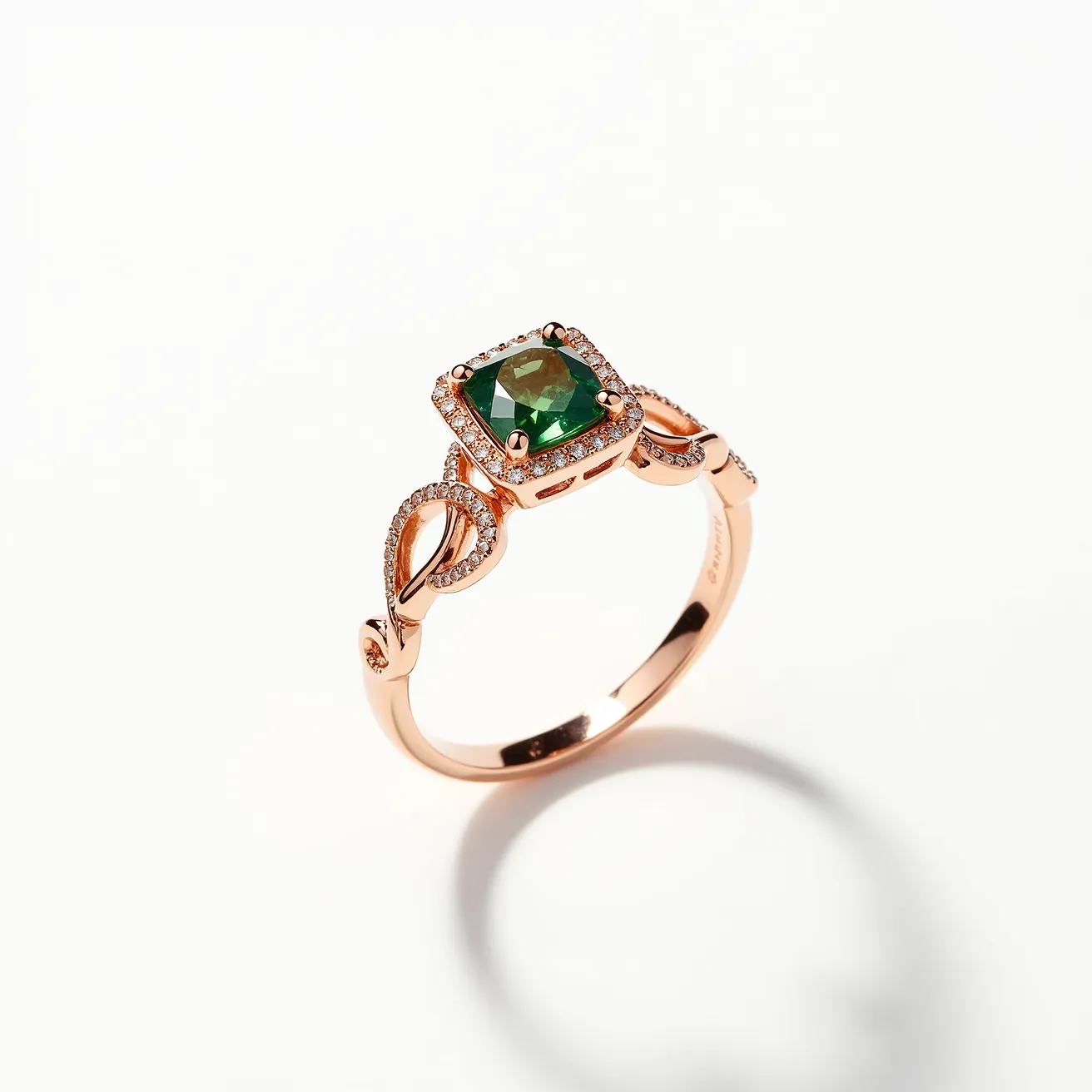 This prasiolite ring features a cushion-cut prasiolite gemstone as the central element, set in a rose gold band. The prasiolite is elegantly secured with four prongs, showcasing its green hue. Encircling the prasiolite is a halo of small, sparkling diamonds, highlighting the main stone's brilliance. The band is intricately designed with an elegant intertwining pattern, embellished with additional diamonds to enhance its luxurious appearance. The combination of the prasiolite's rich color, the rose gold's warm hue, and the diamonds' sparkle creates a sophisticated and eye-catching piece of jewelry.