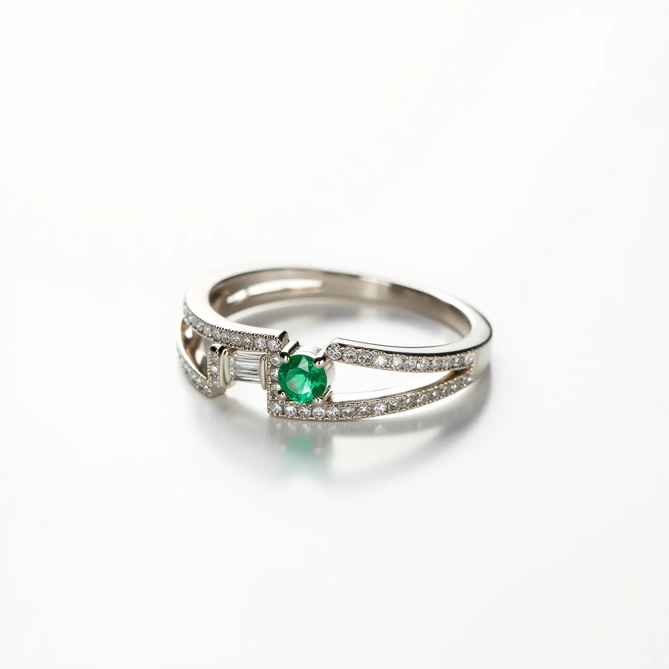 This rainbow ring features a delicate band made of a lustrous metal, possibly white gold or platinum, adorned with a collection of small round-cut diamonds that are pave-set along its split shank. The centerpiece of the design is a vibrant round-cut green gemstone, likely an emerald, securely held by a prong setting that enhances its brilliance. Positioned next to it, a baguette-cut diamond adds an elegant touch, set in a channel or bezel setting. The combination of these elements creates a harmonious blend of colors and cuts, emphasizing the ring's exquisite craftsmanship.