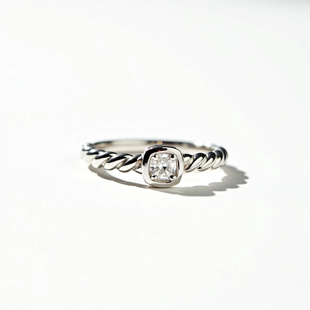 This Rapunzel promise ring features a delicately twisted band, crafted from a lustrous metal, likely silver or white gold, giving it a sleek appearance. The ring boasts a central gemstone, showcased in a cushion cut, set securely in a bezel setting that enhances its brilliance and provides a modern aesthetic. The combination of the twisted band and the sparkling gemstone creates a whimsical yet elegant design, capturing the enchanting essence often associated with Rapunzel-themed jewelry.