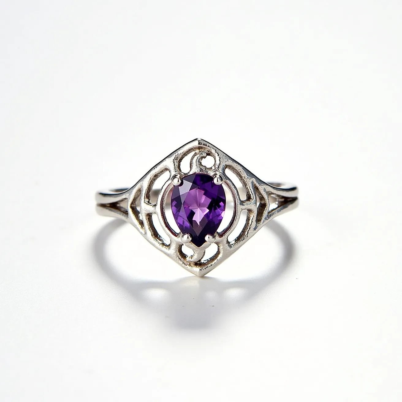 This Rapunzel ring features a beautifully crafted silver band with an intricate, openwork design that frames the centerpiece gem with elaborate, curling details suggestive of flowing vines or hair. At the heart of the ring is a captivating, faceted purple stone, possibly an amethyst, cut in an oval shape, which is securely held in place by four prongs, providing a dazzling focal point. The ring’s artistic and elegant aesthetic combines fairy-tale whimsy with sophisticated craftsmanship, making it a unique and enchanting piece of jewelry.