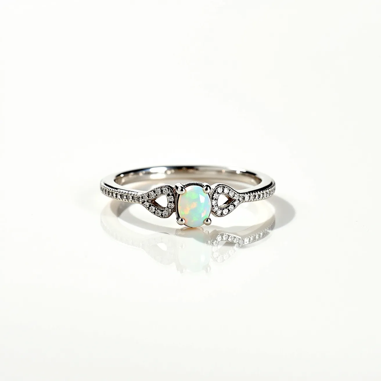 This ring band features a central opal gemstone, characterized by its iridescent play of colors, set in an elegant prong setting. The band itself appears to be made of a shiny metal, likely white gold or platinum, which is known for its durability and lustrous finish. Flanking the opal on either side are small, round-cut diamonds embedded in the band in a pave setting, adding a touch of sparkle and luxury. The overall design of the ring is delicate and graceful, with a unique arrangement that enhances the opal's beauty while providing a secure fit.