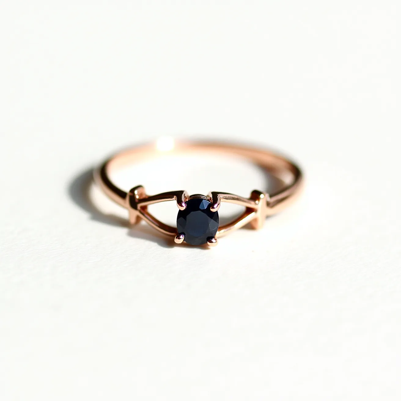 This ring band features a delicate design crafted from rose gold, giving it a warm and luxurious appearance. At its center, a deep blue sapphire is set in a round cut, adding a touch of elegance and sophistication. The sapphire is held securely in place by a four-prong setting, which provides a classic and timeless look while allowing the stone to catch light beautifully from various angles. The slender band complements the gemstone, enhancing the ring's overall refinement and understated elegance.