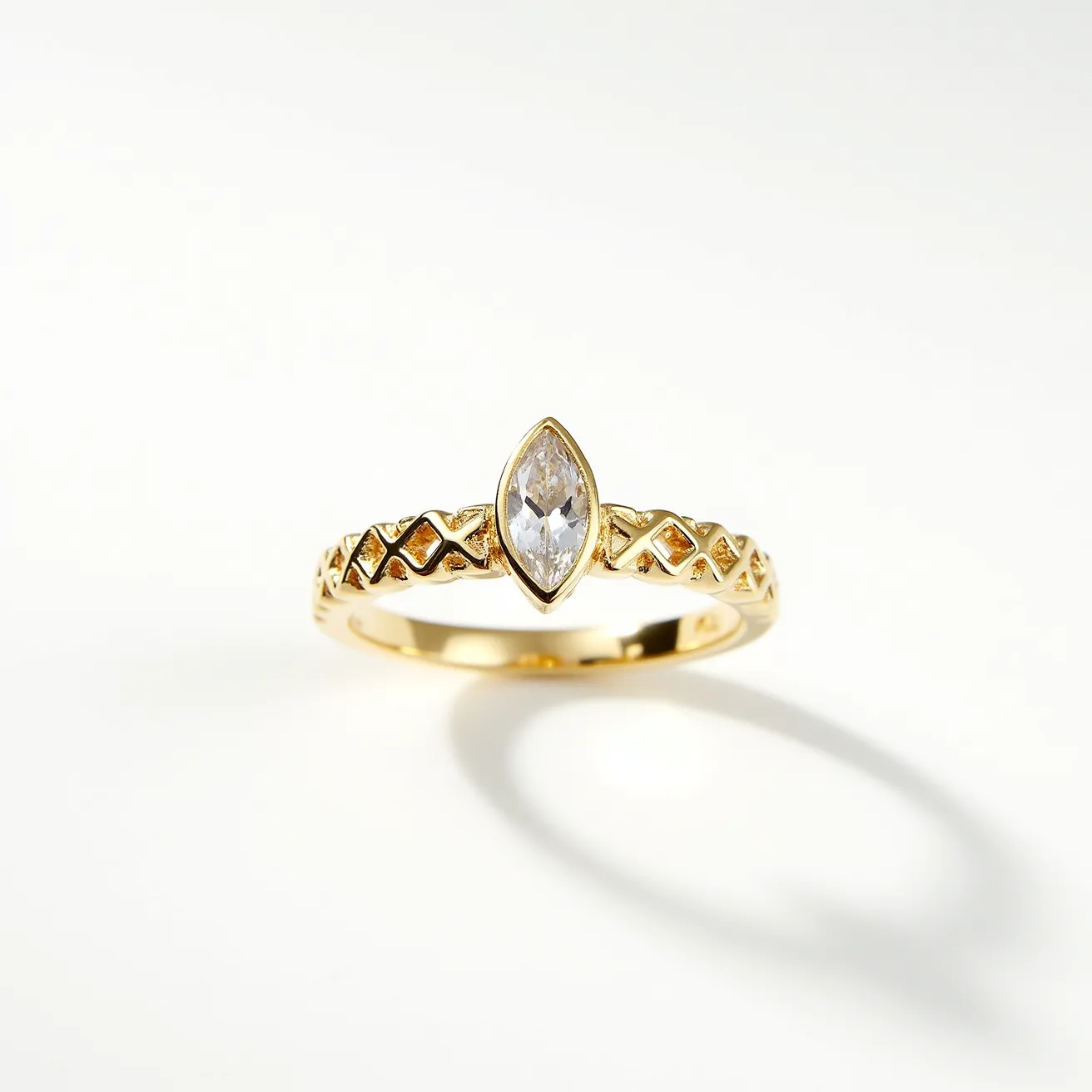 This ring band features a gold material with an intricate lattice-like design along its surface. It is set with a single marquise-cut stone, which appears to be a diamond, held securely in a bezel setting that accentuates its shape and brilliance. The combination of the detailed band and the central gem creates a balanced and elegant appearance.