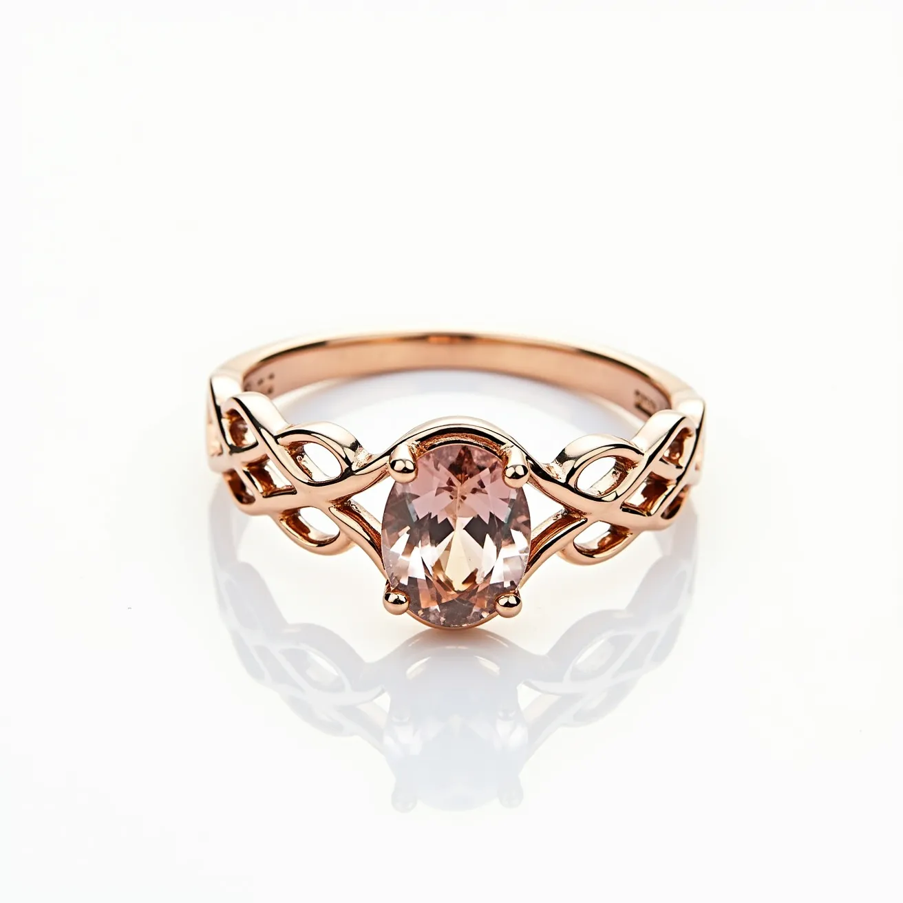 This rose gold ring features an elegant, oval-cut stone set in the center. The gem is securely held in place by a classic prong setting, enhancing its brilliance and showcasing its faceted design. The band itself is crafted from polished rose gold, contributing to the ring's warm and romantic aesthetic. The ring's intricate design includes an open, intertwining pattern on each side of the gem, adding a touch of sophistication and artistic flair without the use of any clasps or attachments. The overall style of the ring combines modern elegance with a hint of vintage charm.