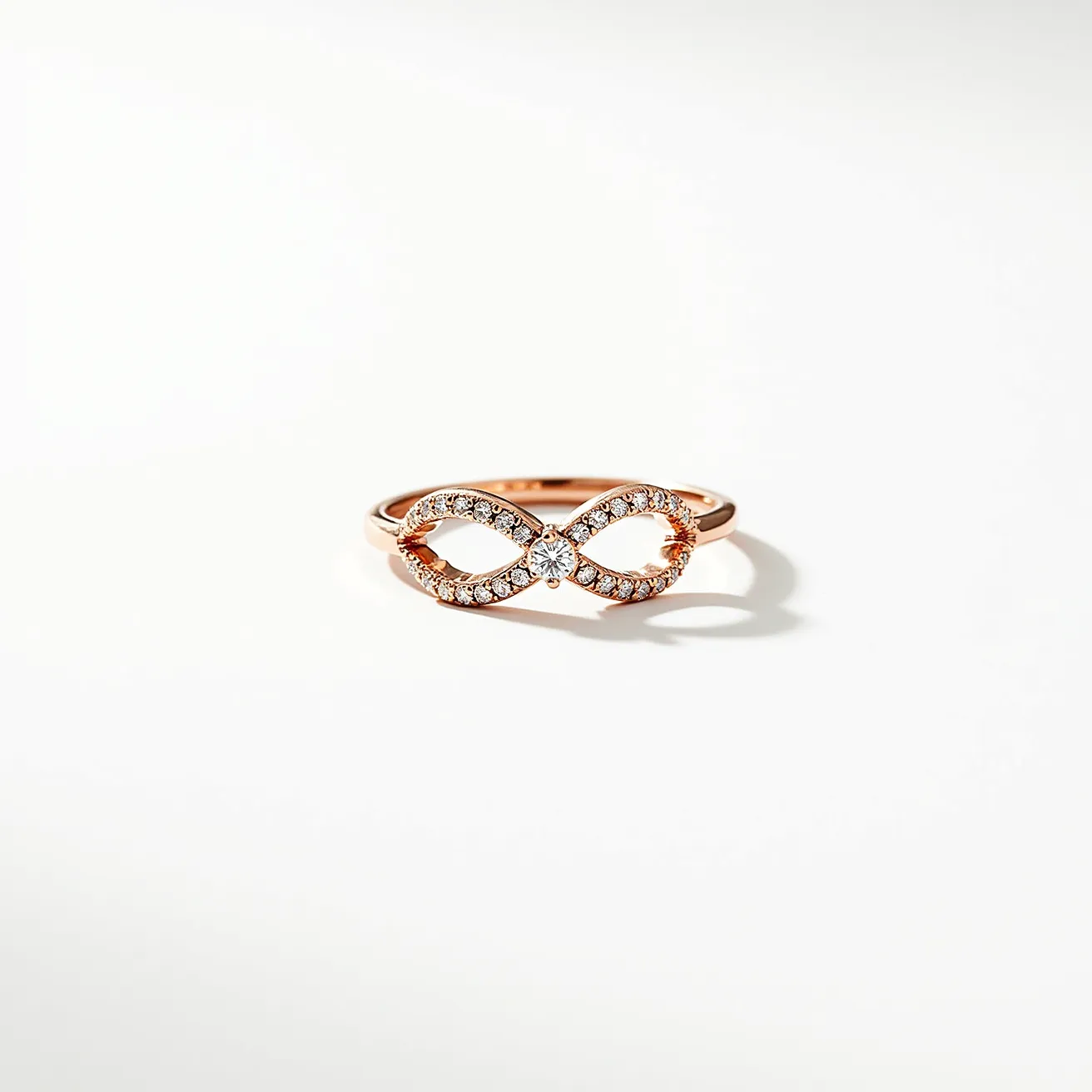 This rose gold ring features an elegant infinity symbol as its central design element, crafted from rose gold and adorned with a series of small round-cut diamonds in a pavé setting, which adds a continuous sparkle to the symbol's curves. At the center of the infinity, a slightly larger round-cut diamond is expertly set, enhancing the ring's focal point and adding to its sophisticated charm. The band smoothly integrates with the infinity motif, maintaining a cohesive and seamless design. The ring's smooth finish and balanced proportions contribute to its timeless and versatile appeal.