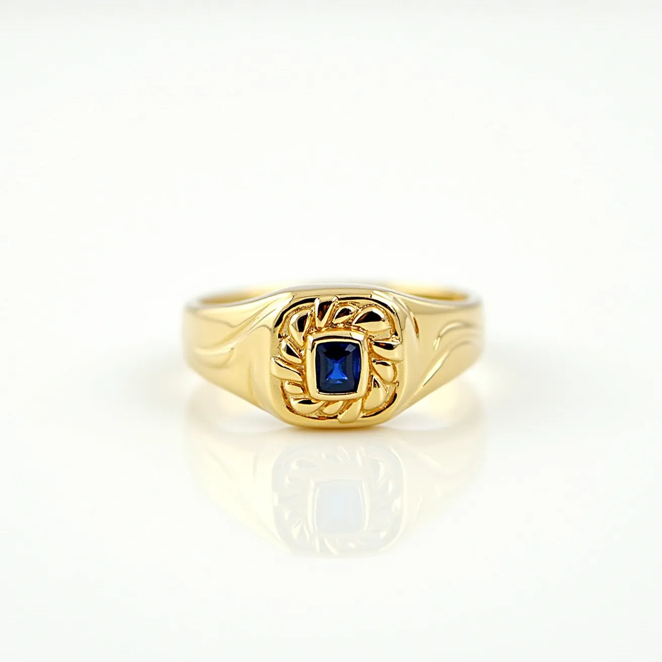 This signet ring features a gold band adorned with intricate engravings on the shoulders, merging into a central design. It is set with a square-cut gemstone, likely a sapphire, held securely in a bezel setting. The dark blue hue of the stone contrasts elegantly with the warm tones of the gold, adding a touch of sophistication to the overall design. The bold and luxurious combination of materials and craftsmanship emphasizes the significance and elegance traditionally associated with signet rings.