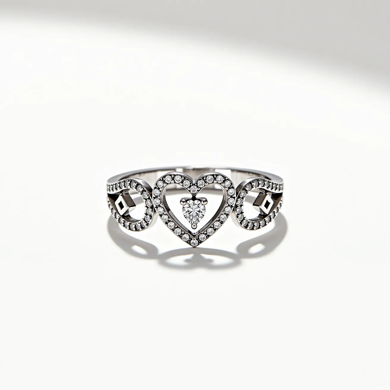 This silver heart ring showcases a central heart shape adorned with small, round-cut gems, likely cubic zirconia or diamonds, encrusted around its outline, creating a sparkling effect. At the center of the heart is a pear-shaped gem set within a closed setting, adding a focal point to the design. Surrounding the heart are two circular elements, each with a geometric gem set prominently, likely in a bezel or prong setting. The band is also accented with a line of small stones, enhancing its overall brilliance. The ring does not include a separate clasp or attachment, as it is constructed as a continuous band.