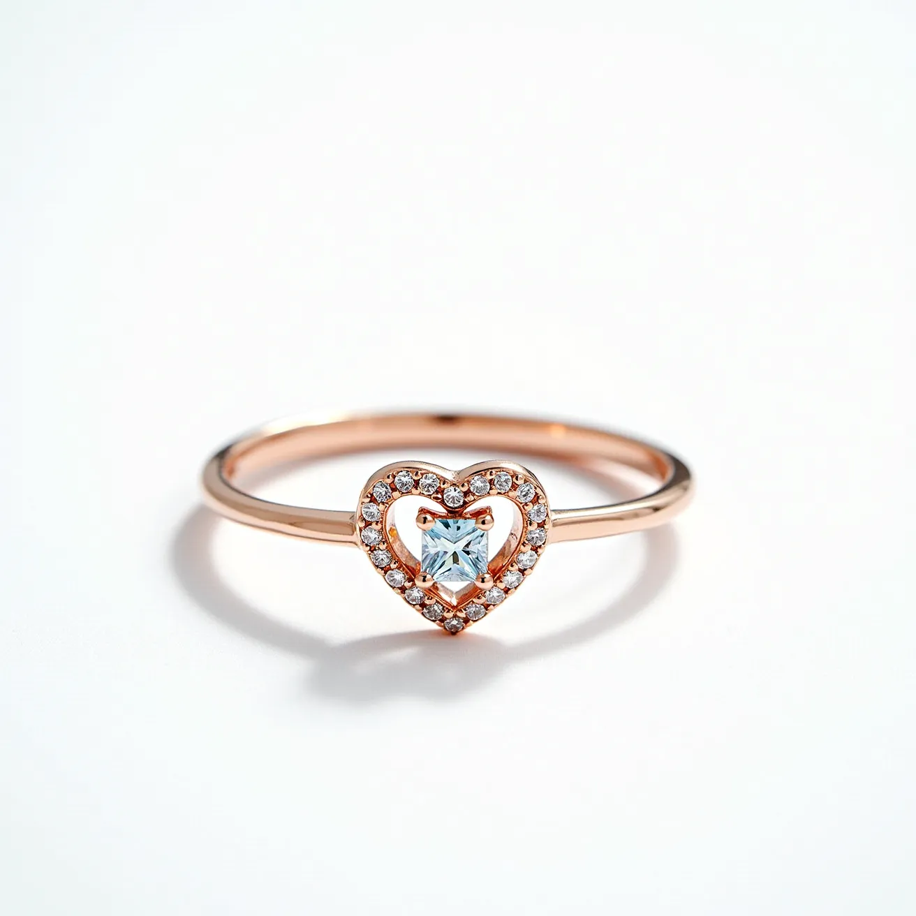 This silver heart ring features a delicate rose gold band with a prominent heart-shaped design at its center. The heart is encrusted with small, round-cut clear stones, likely diamonds or high-quality cubic zirconia, in a pave setting that adds a sparkling frame. At the core of the heart is a square-cut clear stone, secured by four prongs, which serves as the ring’s focal point. The design is elegant and minimalist, emphasizing the central geometric stone and its surrounding accents without additional clasps or attachments.