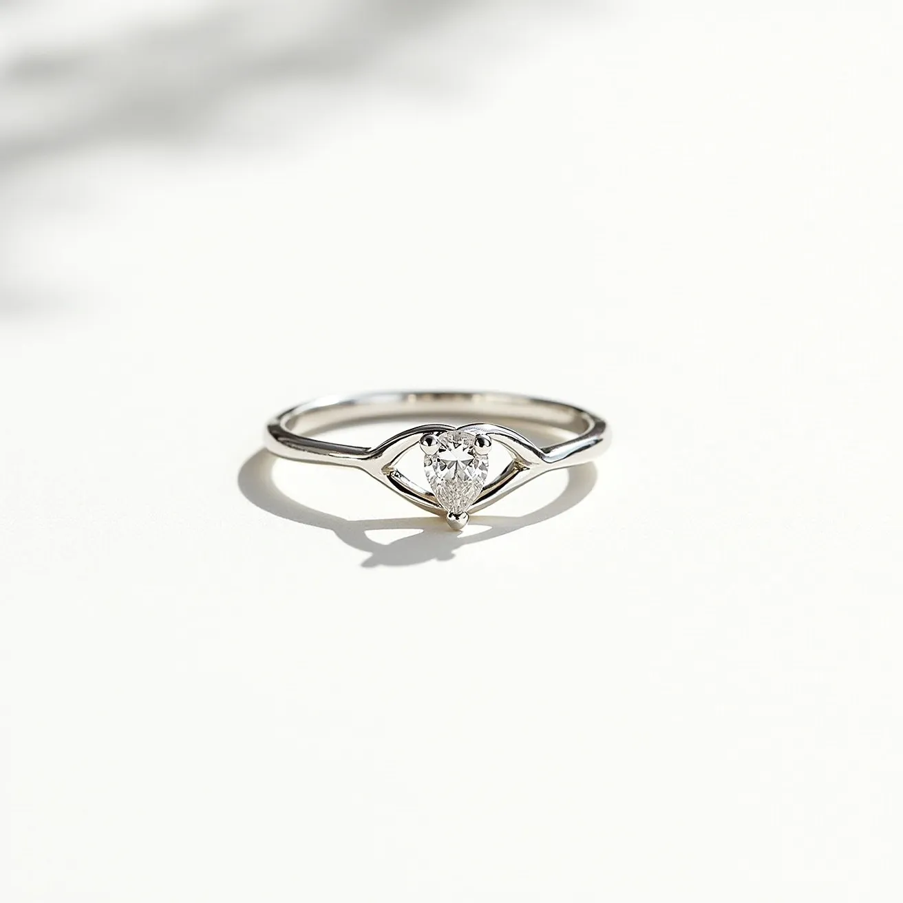 This silver promise ring features a delicate band crafted from polished silver, accentuating its simple elegance. At its center, the ring showcases a heart-shaped gem, possibly a diamond or a clear stone, expertly cut to enhance its brilliance. The gem is set in a classic prong setting, allowing maximum light to pass through while securing it in place. The design is both timeless and symbolic, capturing the essence of commitment and devotion.