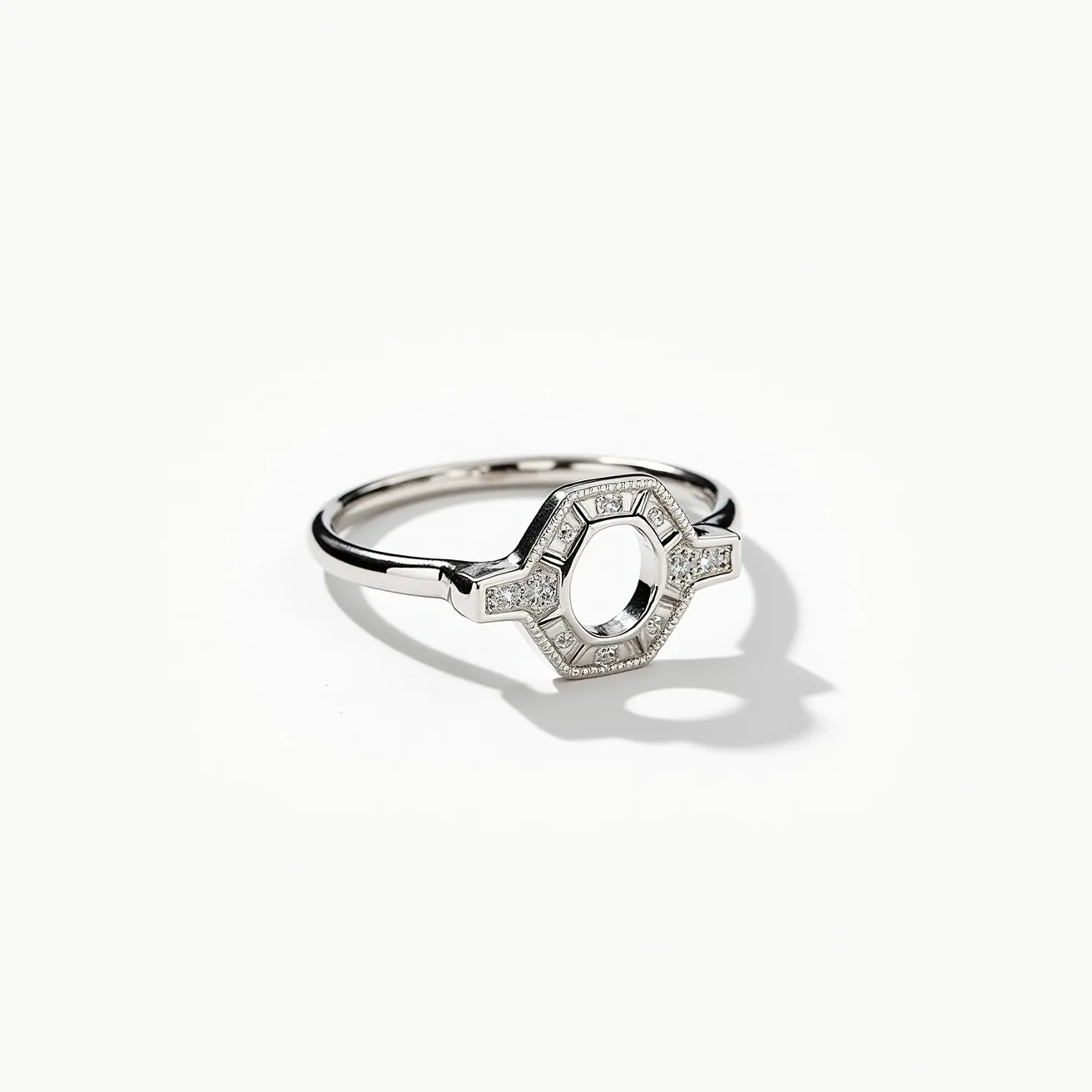 This silver ring features a unique geometric design, incorporating small clear stones set around an open octagonal frame. The stones are accentuated by a pave setting, allowing them to catch light from multiple angles. The band is sleek and polished, seamlessly integrating with the focal design, which creates a modern and sophisticated look. There is no visible clasp or attachment, highlighting its simplicity and elegance.