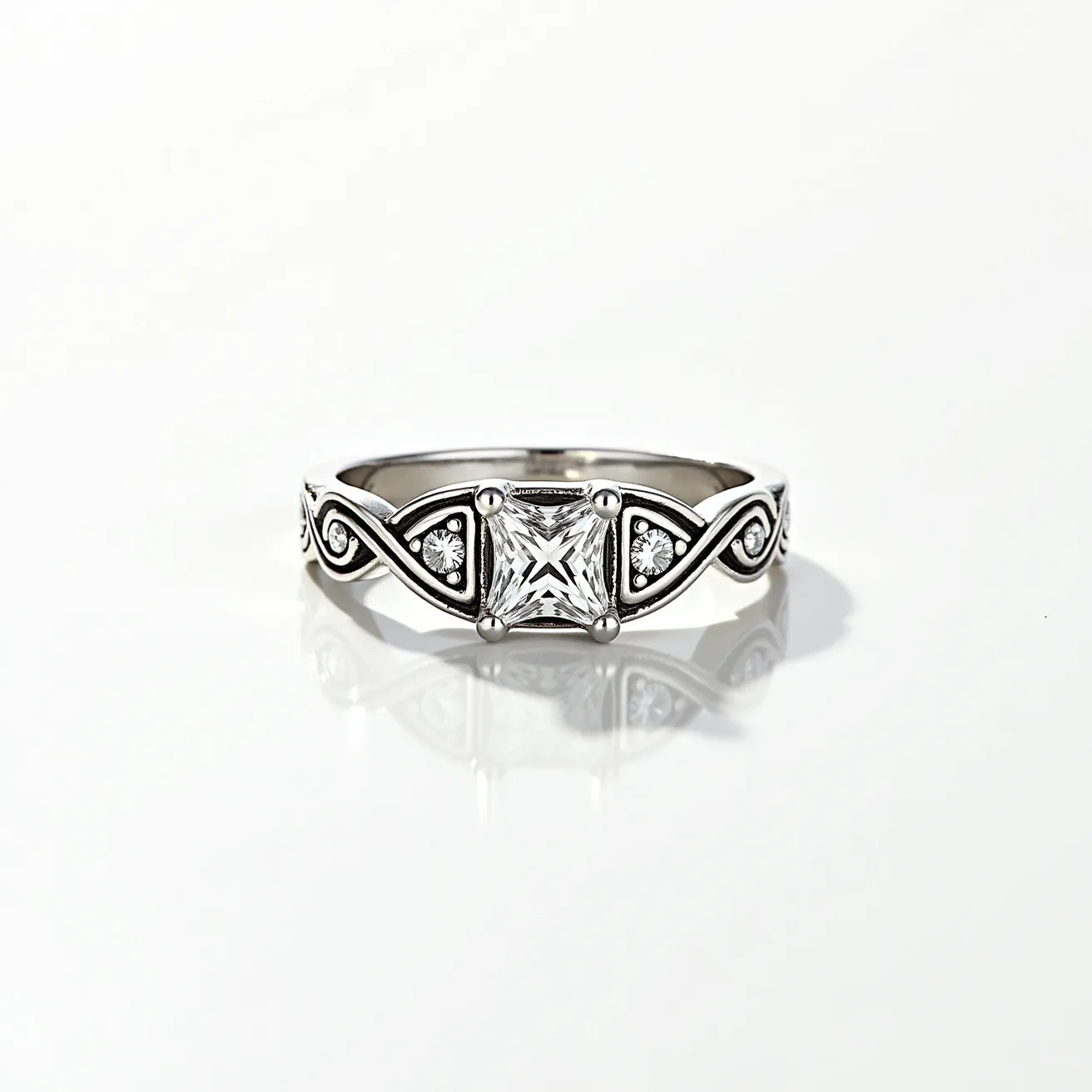 This silver ring is crafted with intricate detailing, featuring a prominent square-cut gem at its center, securely held by a four-prong setting. The band incorporates elegant scrollwork, accentuated by smaller round gems set within triangular frames that add to its decorative appeal. The combination of polished silver and sparkling gems creates a harmonious and sophisticated design.