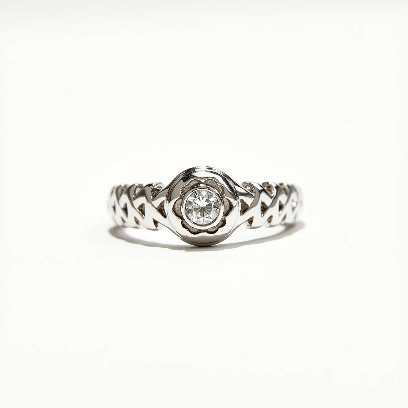 This silver ring features a beautifully crafted design, incorporating a single round-cut gemstone prominently placed in the center. The stone is securely held in a bezel setting, allowing it to catch and reflect light elegantly. The band itself displays an intricate pattern of interconnected shapes, enhancing the overall aesthetic and artistic appeal. The choice of silver as the primary material provides a sleek and polished appearance, complementing the clarity and brilliance of the gemstone. Its craftsmanship and design suggest attention to detail, making it a distinct and stylish piece.