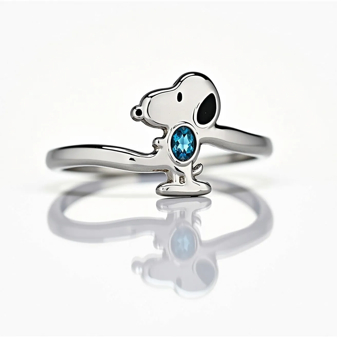 This Snoopy ring features a sleek and polished metal band likely made of sterling silver or white gold, shaped into the iconic form of Snoopy. Prominently displayed at the center of Snoopy's body is a vibrant, oval-cut blue gemstone set into the metal, which adds a touch of elegance and color to the design. The gemstone is securely held in place with a bezel setting, enhancing the ring's seamless appearance. The ring has a minimalist style, focusing on the charm of the familiar character intertwined with a touch of sophistication through the incorporated gem.