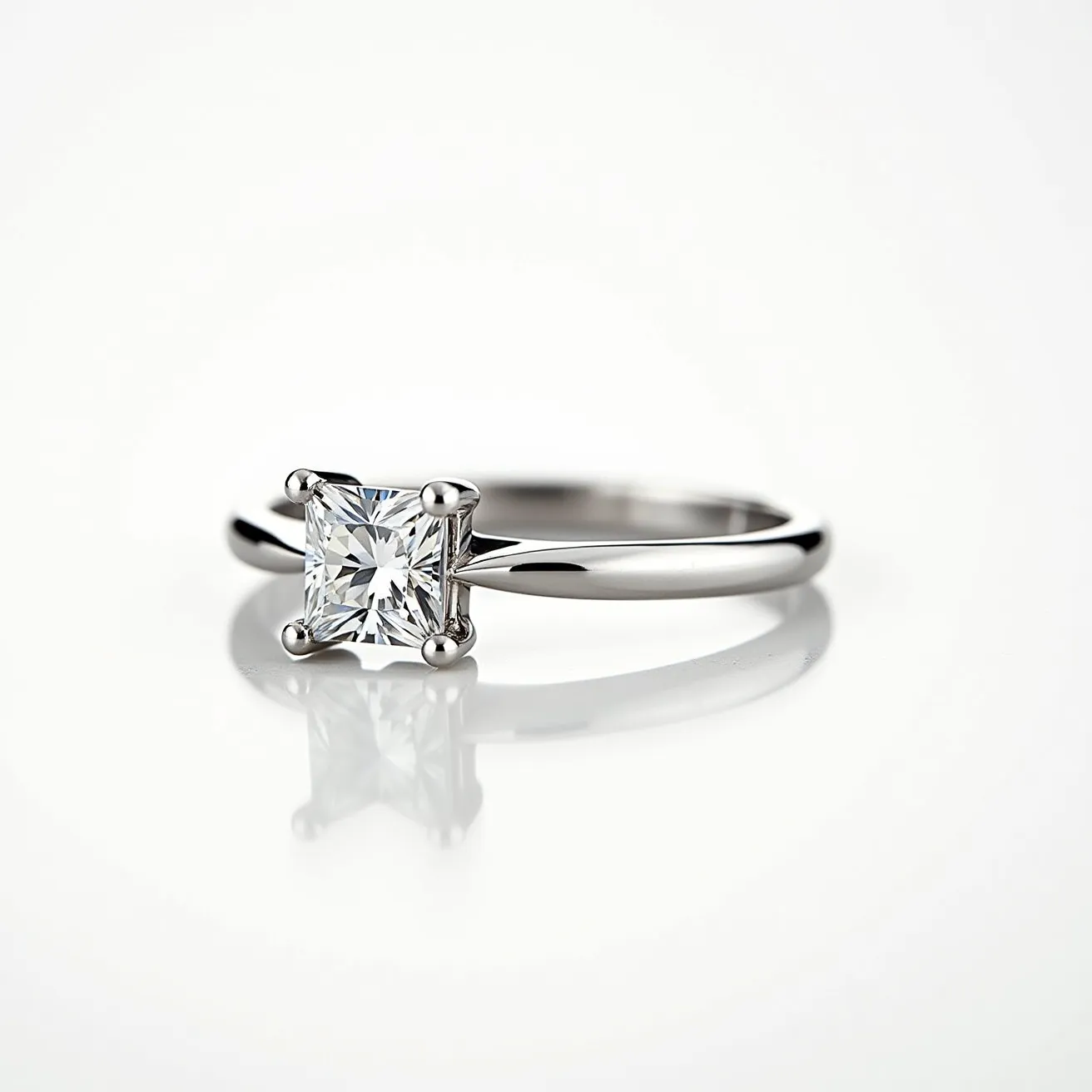 This solitaire ring features a sleek metal band, likely made from platinum or white gold, supporting a striking square-cut gemstone. The centerpiece appears to be a sparkling diamond, securely set in a classic four-prong setting that showcases its brilliance and clarity. The prongs are smoothly integrated into the design, offering both security and an uncluttered aesthetic that highlights the stone's geometric precision. The overall look is elegant and timeless, emphasizing the beauty of the solitaire gem.