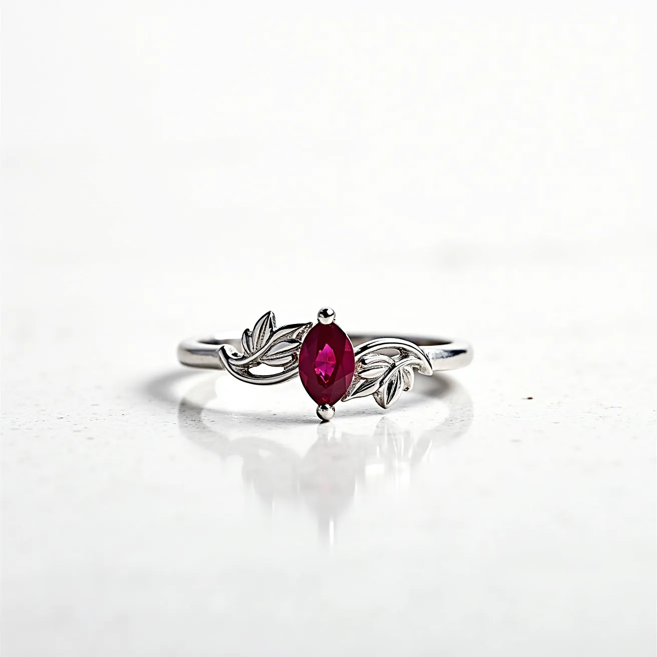 This Solomon's ring features a sleek metal band with intricate leaf motifs on either side, enhancing its elegant design. At the center is a marquise-cut red gem, secured with a prong setting that accentuates its vibrant color and pointed edges. The refined craftsmanship of the band and the strategic placement of the decorative elements create a harmonious aesthetic that makes this piece visually captivating.