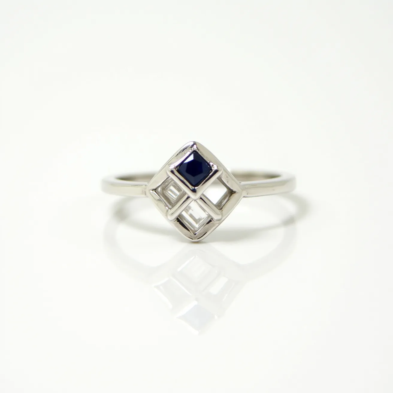 This Solomon's ring is crafted from a sleek metal, likely silver or white gold, featuring a geometric openwork design at its center. The focal point is a deep blue gemstone, likely a sapphire, cut into a square shape and set centrally within a diamond-shaped frame. The stone is secured in a bezel setting, enhancing its stability and highlighting its facets. The ring band is simple and unadorned, ensuring the central design remains prominent and striking.