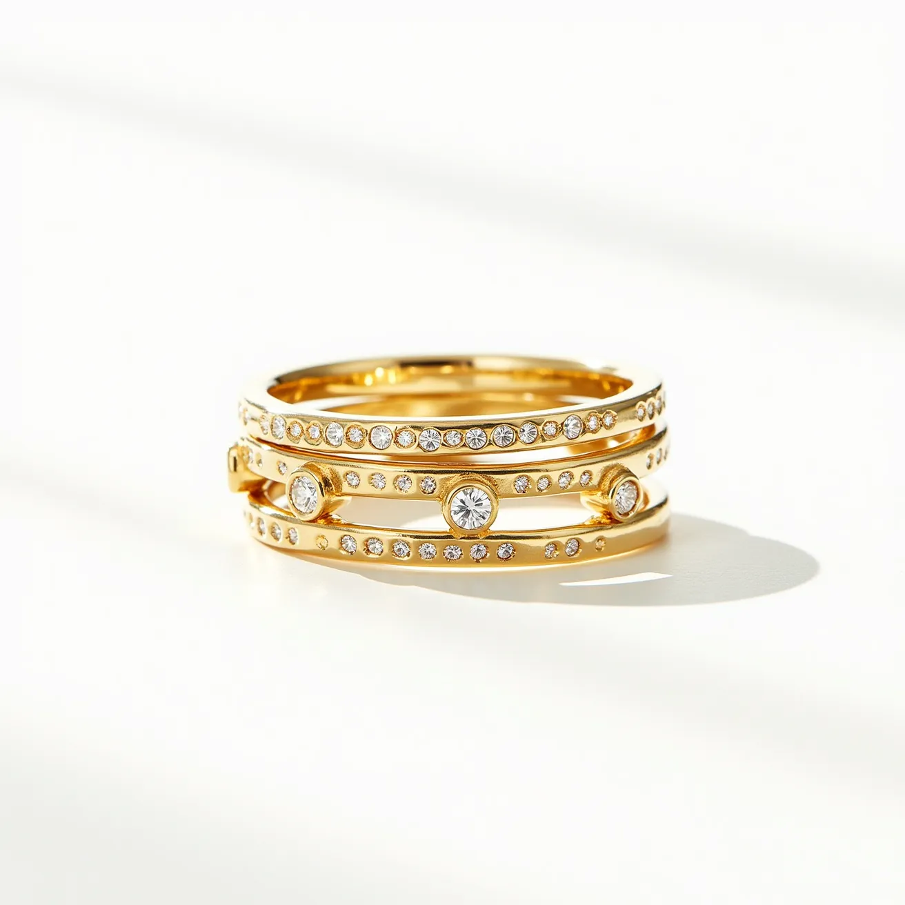 These stackable diamond rings are crafted from a lustrous gold material, featuring a series of intricately set round diamonds. The gems appear to be brilliant-cut, providing maximum sparkle and precision, arranged in a pavé setting that enhances their brilliance along the bands. Featured prominently in bezel settings are larger diamonds, adding an element of elegance and focal points to the design. The rings are designed for stacking, allowing for versatile combinations and styling options without the need for clasps or attachments, offering both sophistication and versatility in their design.