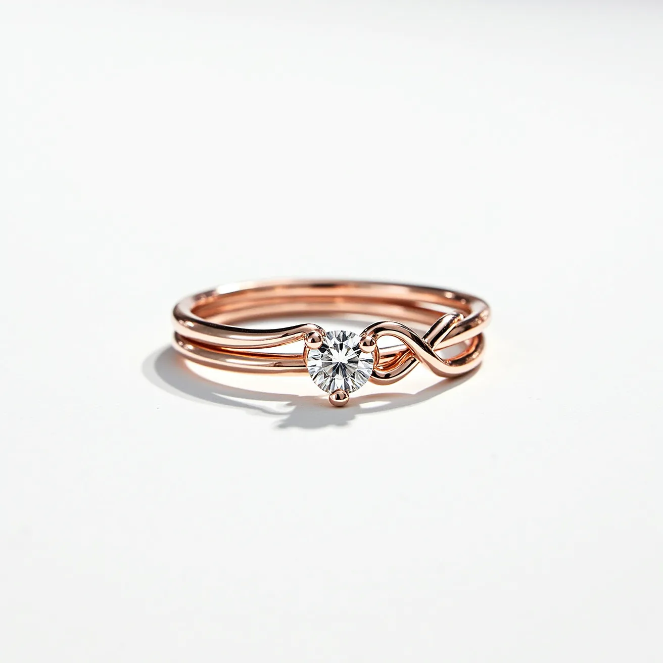 This stackable engagement ring features a delicate design crafted from rose gold. It includes a single round-cut diamond at the center, secured with a prong setting that highlights the stone's brilliance. The band is elegantly twisted, creating a smooth, intertwined appearance. This design enhances the ring's visual interest and adds a modern touch to its classic elegance.