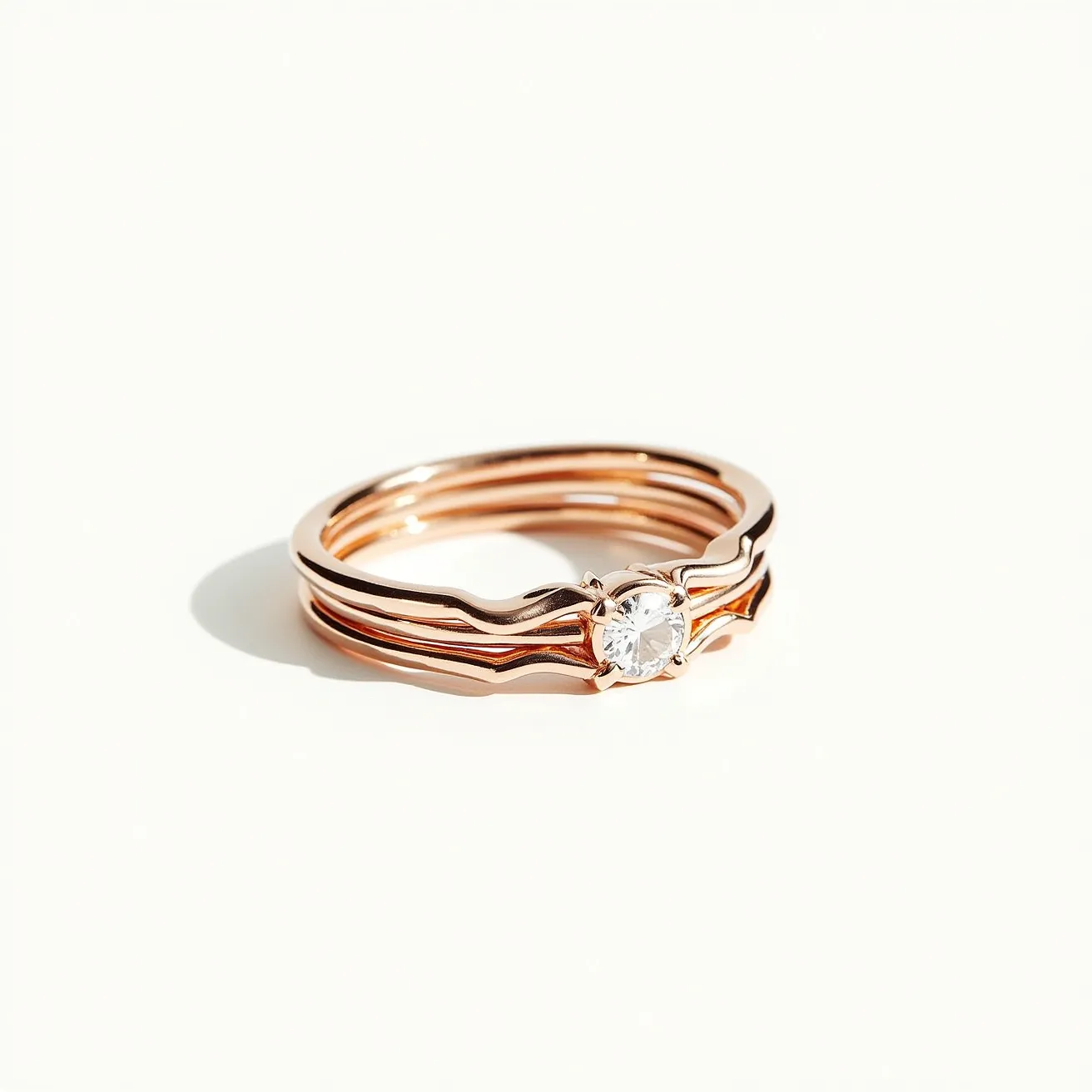 These stackable rings are crafted from rose gold, featuring a sleek, polished finish that allows them to interlock seamlessly. The centerpiece is a single round-cut diamond, held securely in a classic prong setting that enhances its brilliance. The minimalist design focuses on the elegant combination of the gold and the gemstone, with no visible clasps or additional attachments, allowing the rings to be stacked or worn individually.