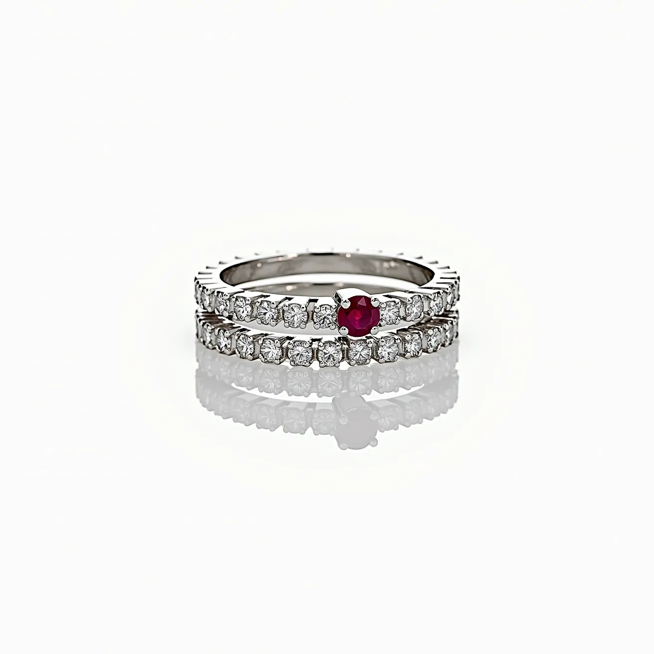 These stacked wedding rings are elegantly crafted from a high-polish metal, likely white gold or platinum, which provides a sophisticated shine. Each band is encrusted with a series of round-cut diamonds, uniformly set in a prong setting that enhances their brilliance and sparkle. One of the rings prominently features a striking round-cut ruby, set in the center of the band, adding a vibrant splash of color to the ensemble. The combination of the diamonds and the ruby creates a harmonious balance, making the rings a beautiful symbol of unity and love.