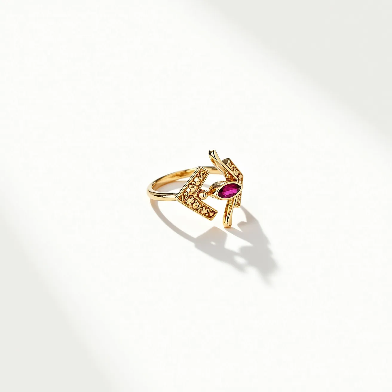 This statement ring features a striking design crafted from polished gold metal. At its center, there is a marquise-cut stone in a rich, deep pink hue, likely a ruby or a similar gemstone, secured in a bezel setting. The design includes geometric gold bars that appear to be studded with smaller, light-catching stones, possibly diamonds or cubic zirconia, enhancing the ring's luxurious appeal. The absence of a clasp or attachment indicates it's a traditional ring style, designed to slip comfortably onto the wearer's finger.