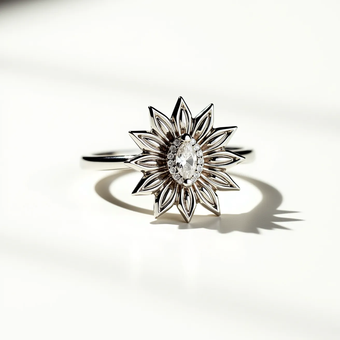 This sunflower ring features a striking design with a central marquise-cut gemstone, likely a diamond or a clear crystal, set prominently in the center. The stone is elegantly surrounded by a halo of smaller stones, enhancing its brilliance and adding an extra element of sparkle. The sunflower petals are crafted from a polished metal, possibly silver or white gold, with a reflecting surface that radiates light beautifully. The band is simple and sleek, seamlessly attaching to the sunflower motif without visible clasps or attachments, creating a harmonious and elegant overall appearance.