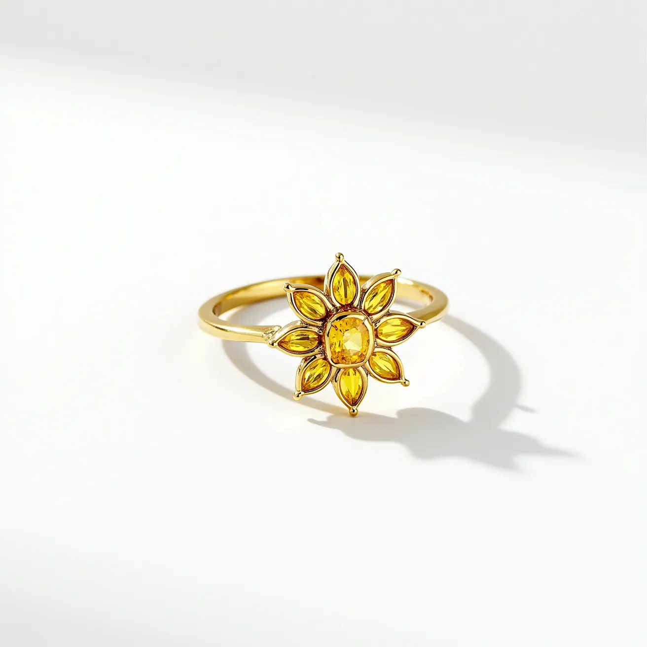 This sunflower ring features a striking design with the petals crafted from a gold-colored material, forming a radiant floral motif. At the center of the sunflower is an oval-cut gemstone in a deep yellow hue, surrounded by smaller marquise-cut gems that create the appearance of sunflower petals. The stones are set in a bezel setting, providing a secure and polished look. The overall composition is elegant, with a delicate band supporting the flower, enhancing its sophisticated and natural-inspired appeal.