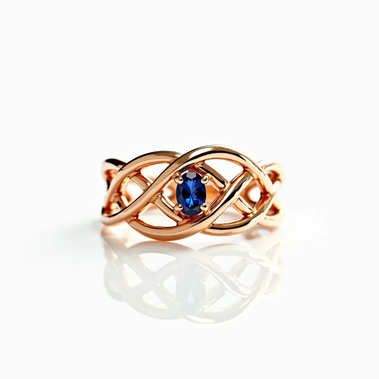 This tangled ring features an intricate lattice design crafted from polished rose gold, providing a warm and luxurious appearance. At its center, the ring showcases a striking blue oval-cut gemstone, likely a sapphire, which is securely held in place by a four-prong setting. The crisscross pattern of the band adds to its elegance and complexity, making it an eye-catching piece of jewelry. There are no visible clasps or attachments, as is typical for rings of this style, emphasizing its seamless and continuous form.