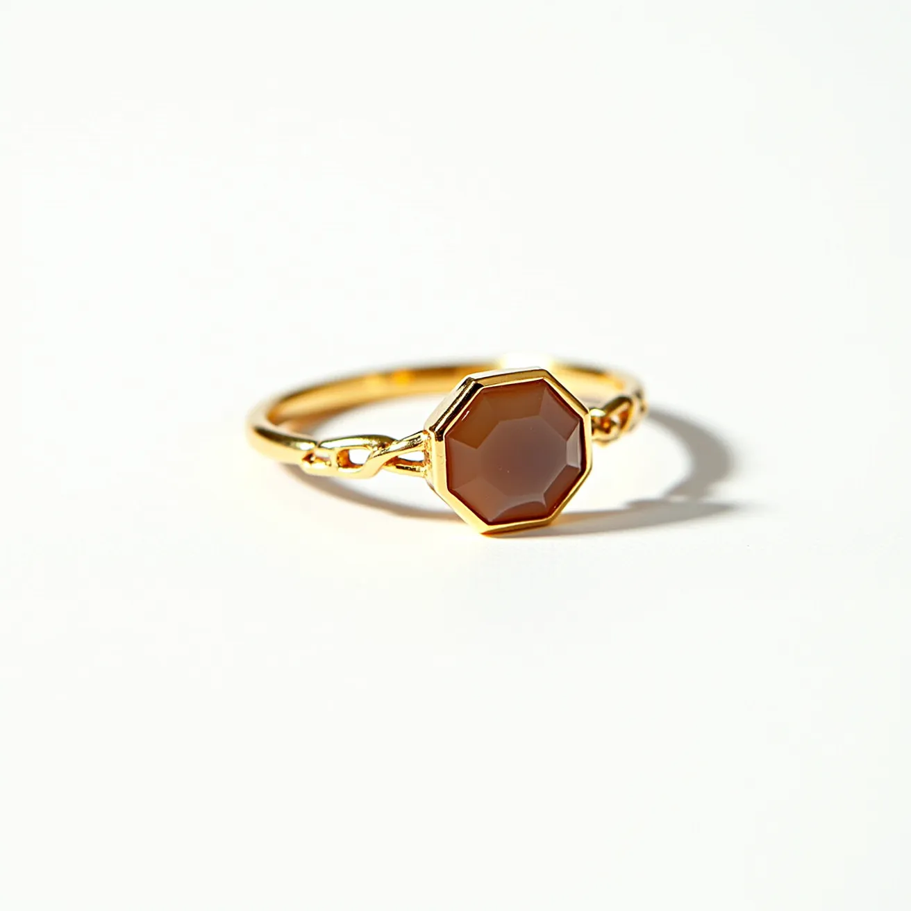 This thumb ring features a sleek, gold band with elegant, minimalist design elements. It prominently showcases a faceted gemstone at its center, set within an octagonal bezel that complements the stone’s shape. The gem exhibits a warm, earthy brown hue, and its polished surface adds a subtle shine to the overall aesthetic. The ring band is enhanced with delicate, twisted detailing on either side of the centerpiece, adding a touch of sophistication and uniqueness. The ring is seamless, without any visible clasps or attachments, emphasizing its simplicity and elegance.