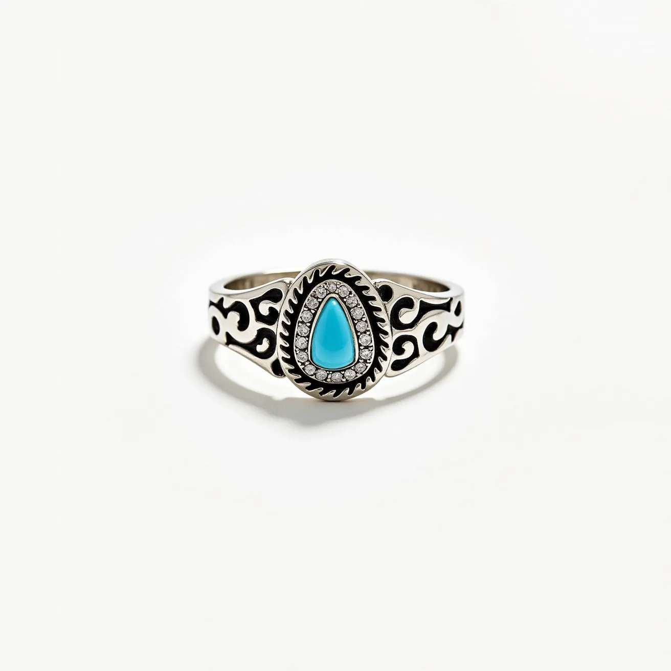 This thumb ring features a striking design with a prominent turquoise gemstone at the center, crafted in a teardrop shape. The turquoise is surrounded by a series of clear, round-cut stones set in a bezel setting that adds an elegant accent to the vibrant blue. The band itself is intricately designed with swirling patterns, likely made from silver, which enhances its ornate appearance. There are no clasps or attachments, as is typical for a solid ring, ensuring a smooth, continuous band. The overall design combines both boldness and intricacy, creating a unique statement piece.