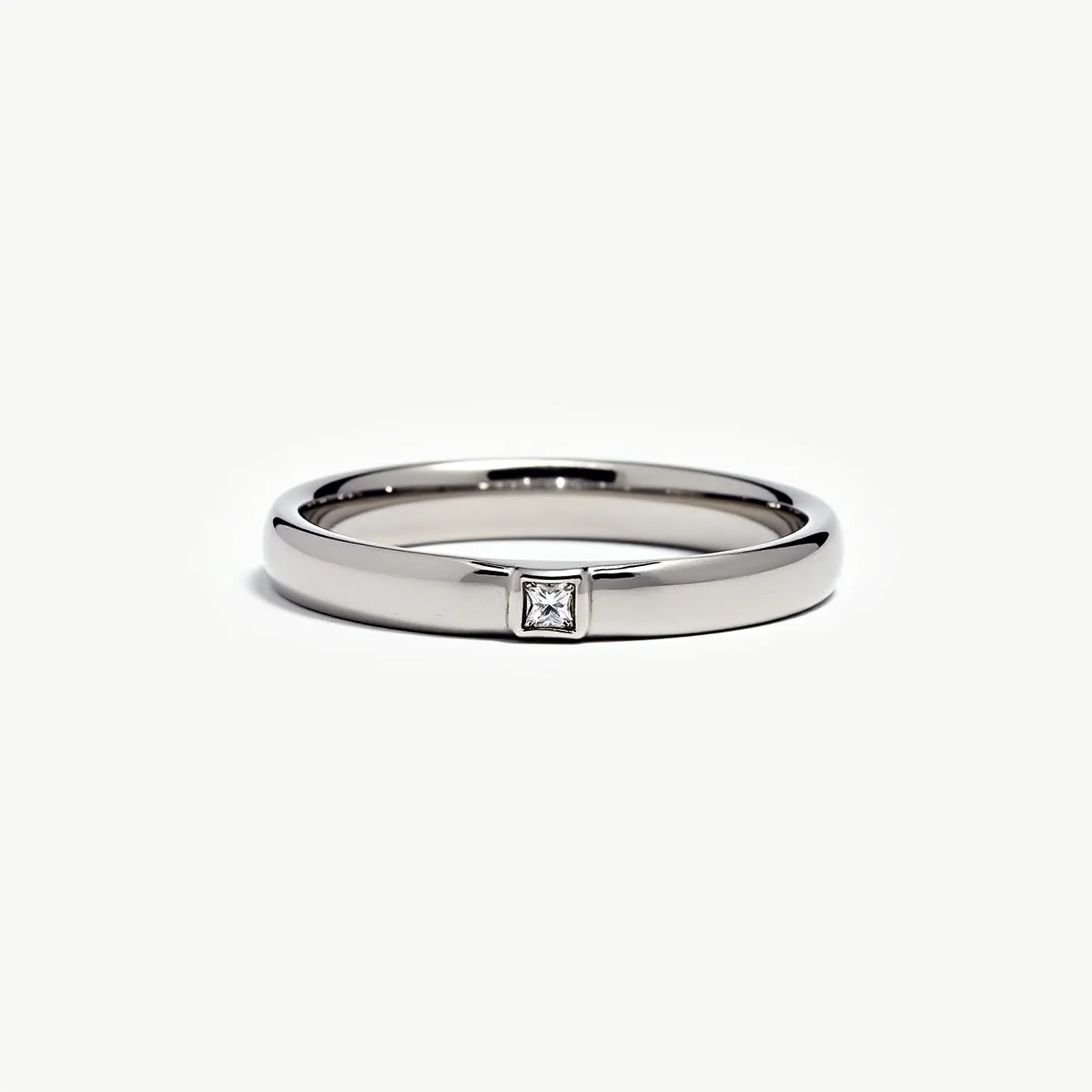 This tungsten ring features a sleek, metallic band with a polished finish, embodying durability and a modern aesthetic. It is adorned with a single, centrally set princess-cut gem, likely a diamond, that adds a touch of elegance and sophistication. The stone is set in a bezel setting, which secures the gem within a fine metal rim, offering both security and a seamless appearance. The ring’s understated and contemporary design makes it a versatile piece suitable for both daily wear and special occasions.