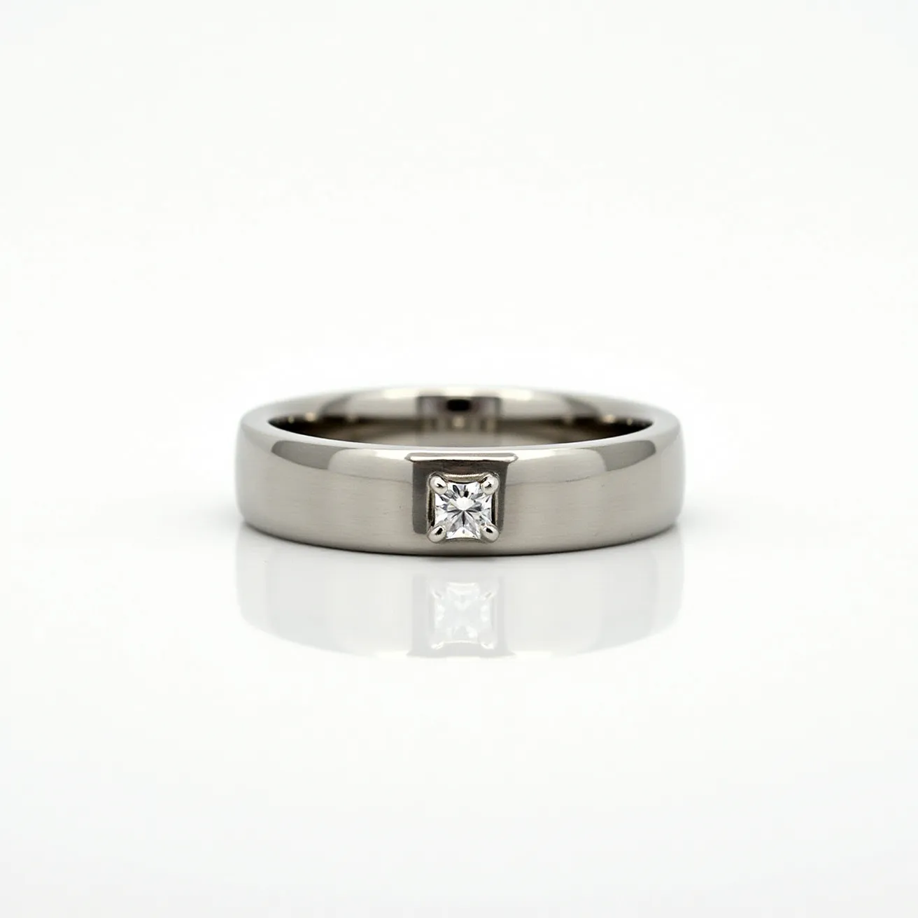 This tungsten ring features a sleek, smooth design with a prominent single gemstone set in its center. The stone is a square-cut, likely a diamond, securely held in place by a bezel setting, which provides both stability and a clean aesthetic. The tungsten material of the ring offers a robust, metallic sheen, enhancing the overall modern and sophisticated appearance of the jewelry piece. 